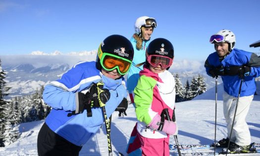 Eltern mit ihren Kindern beim Skifahren lernen.