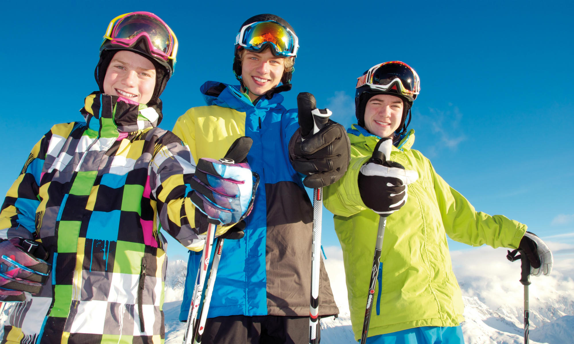 3 Teenager beim Skifahren zeigen Daumen hoch.