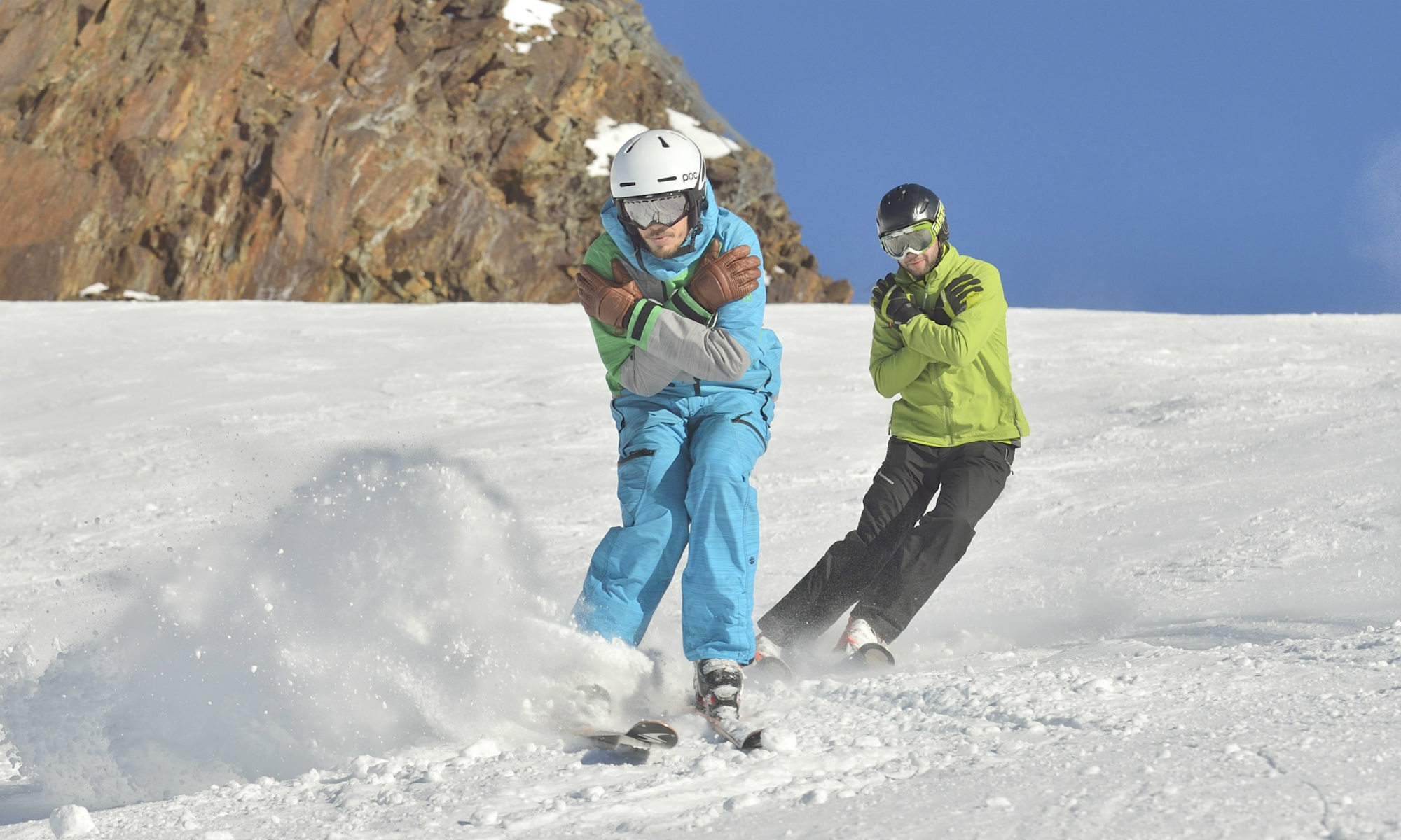 Deux personnes sur une piste de ski ensoleillée font des exercices techniques.
