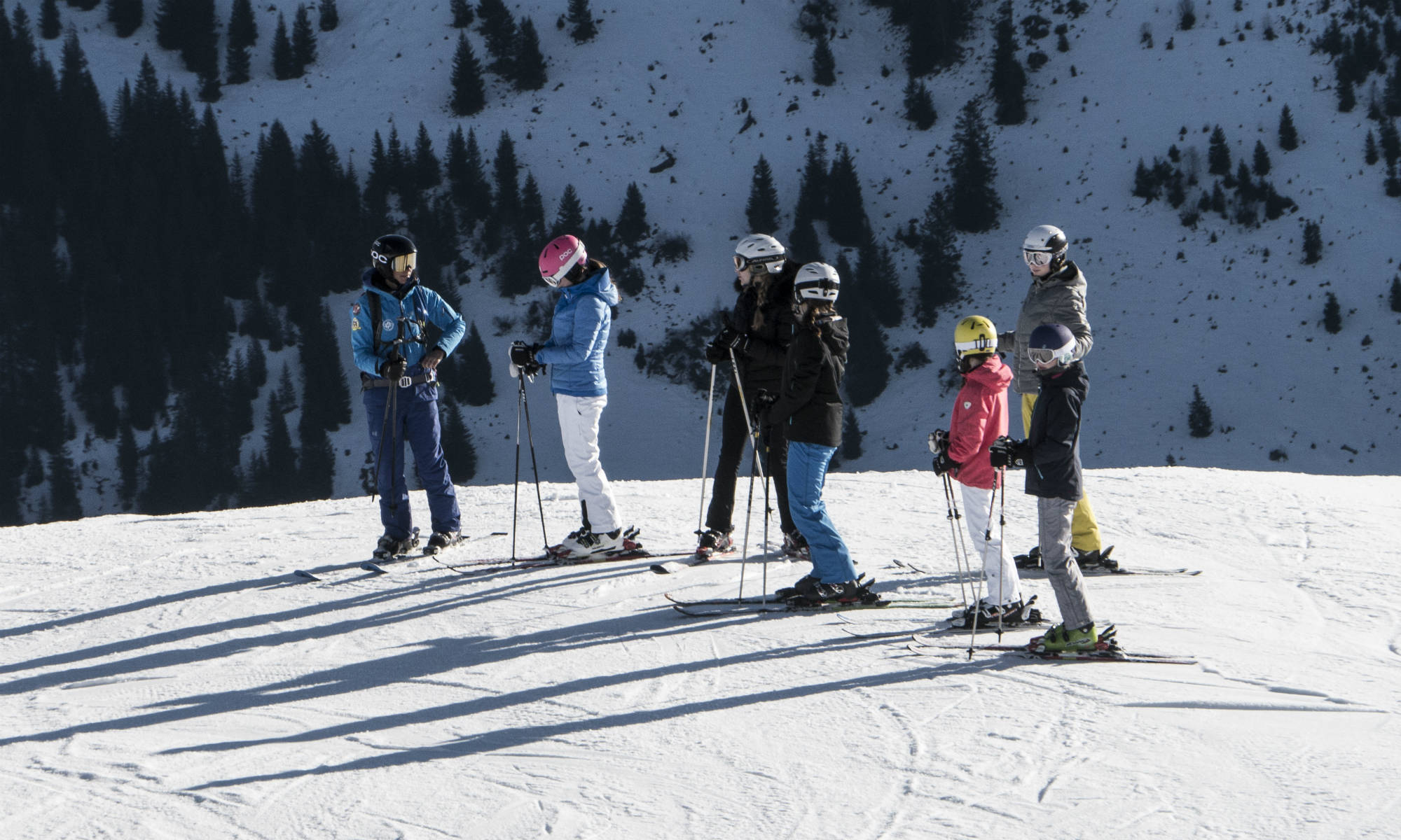 Un groupe d'apprentis skieurs avec leur moniteur de ski lors d'un cours collectif.