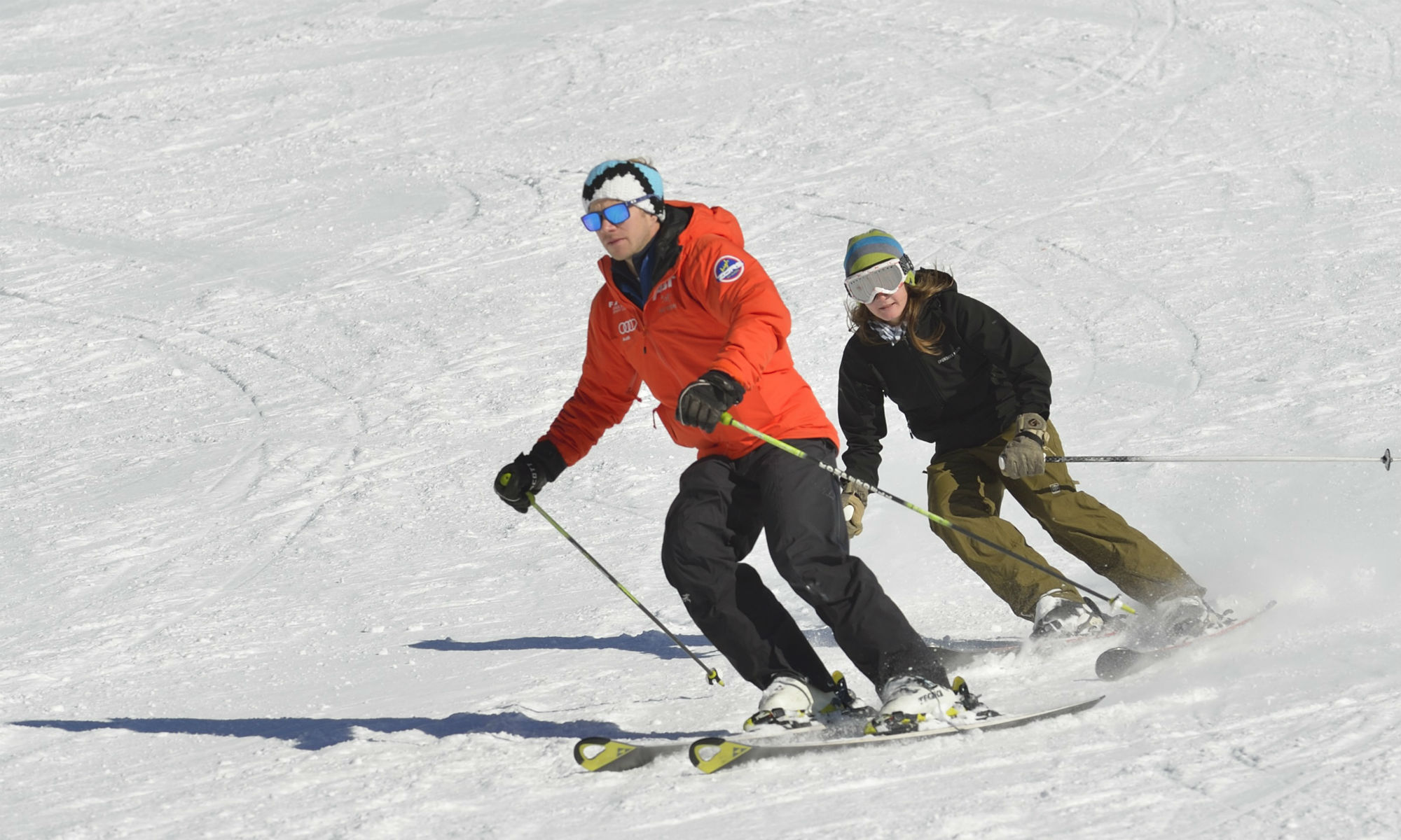 Due sciatori che sciano in pista.
