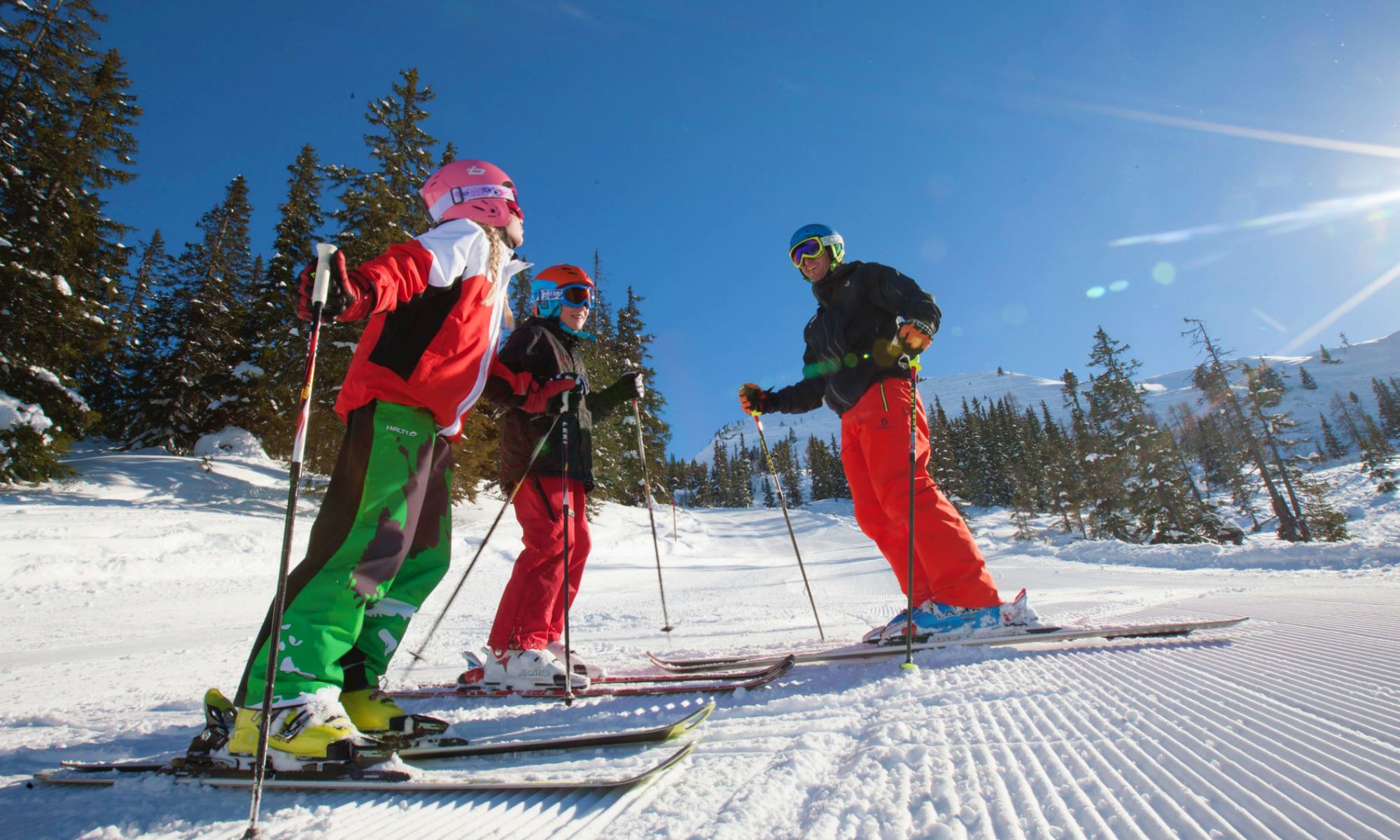 An instructor plus two skiers on the slopes.