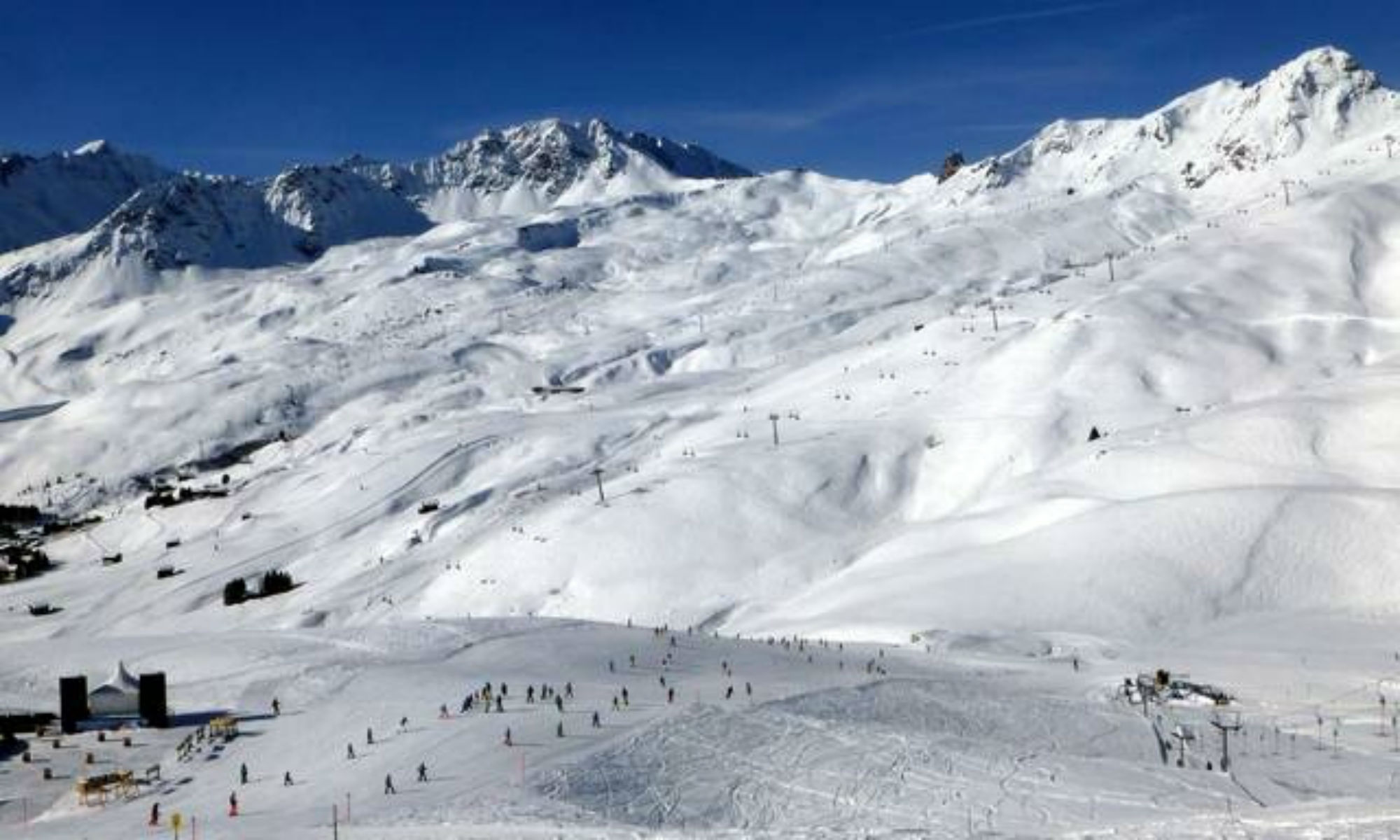 Tief verschneite Pisten im Skigebiet Arosa Lenzerheide bei sonnigem Wetter.