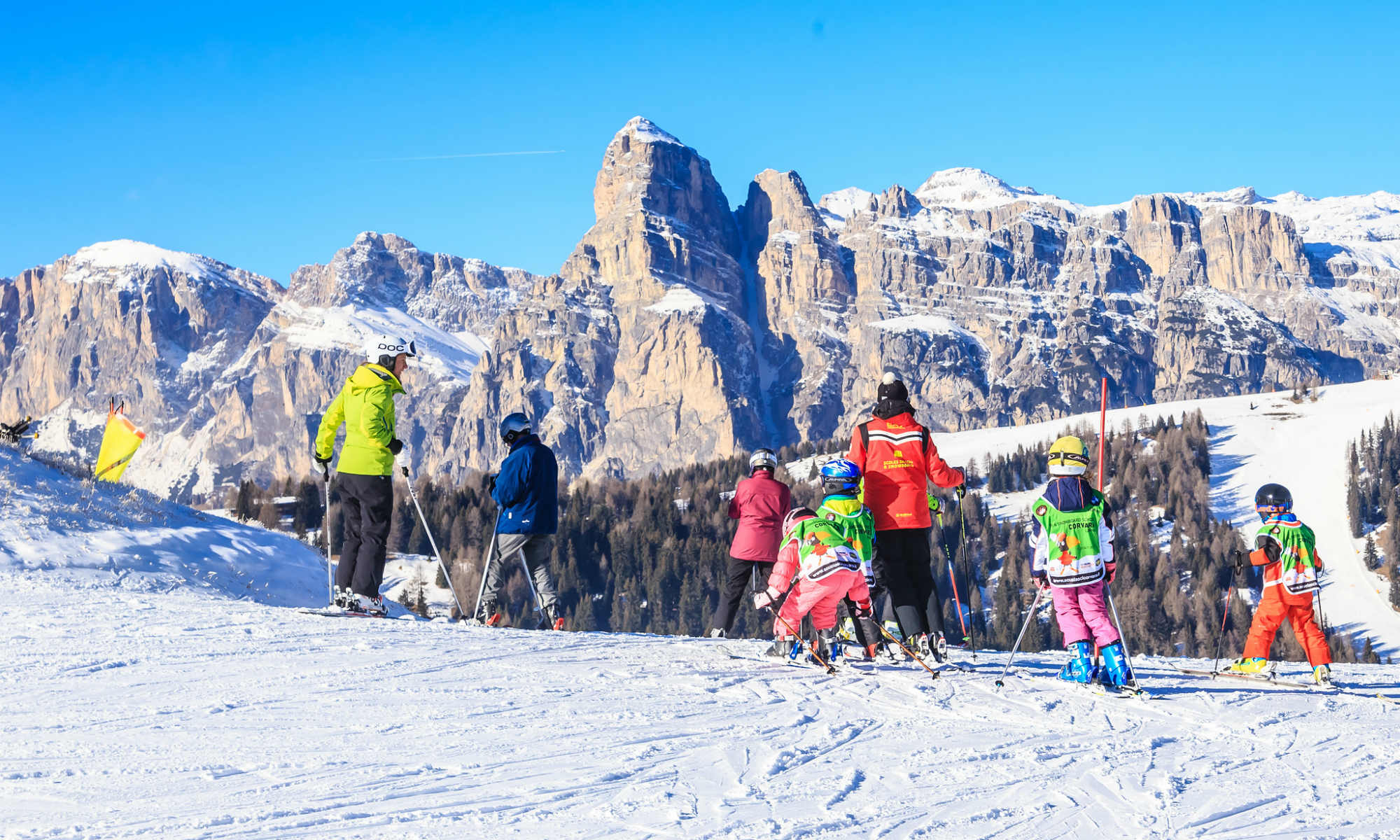 Kinder Skikurs vor der Kulisse der Dolomiten.