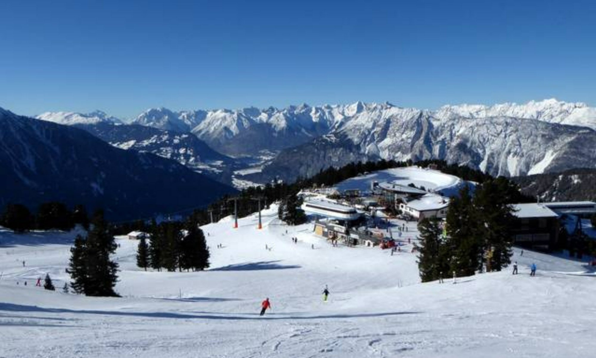 Ausblick vom Skigebiet Oetz-Hochoetz auf die Bergstation der Acherkogelbahn und die umliegende Berglandschaft.