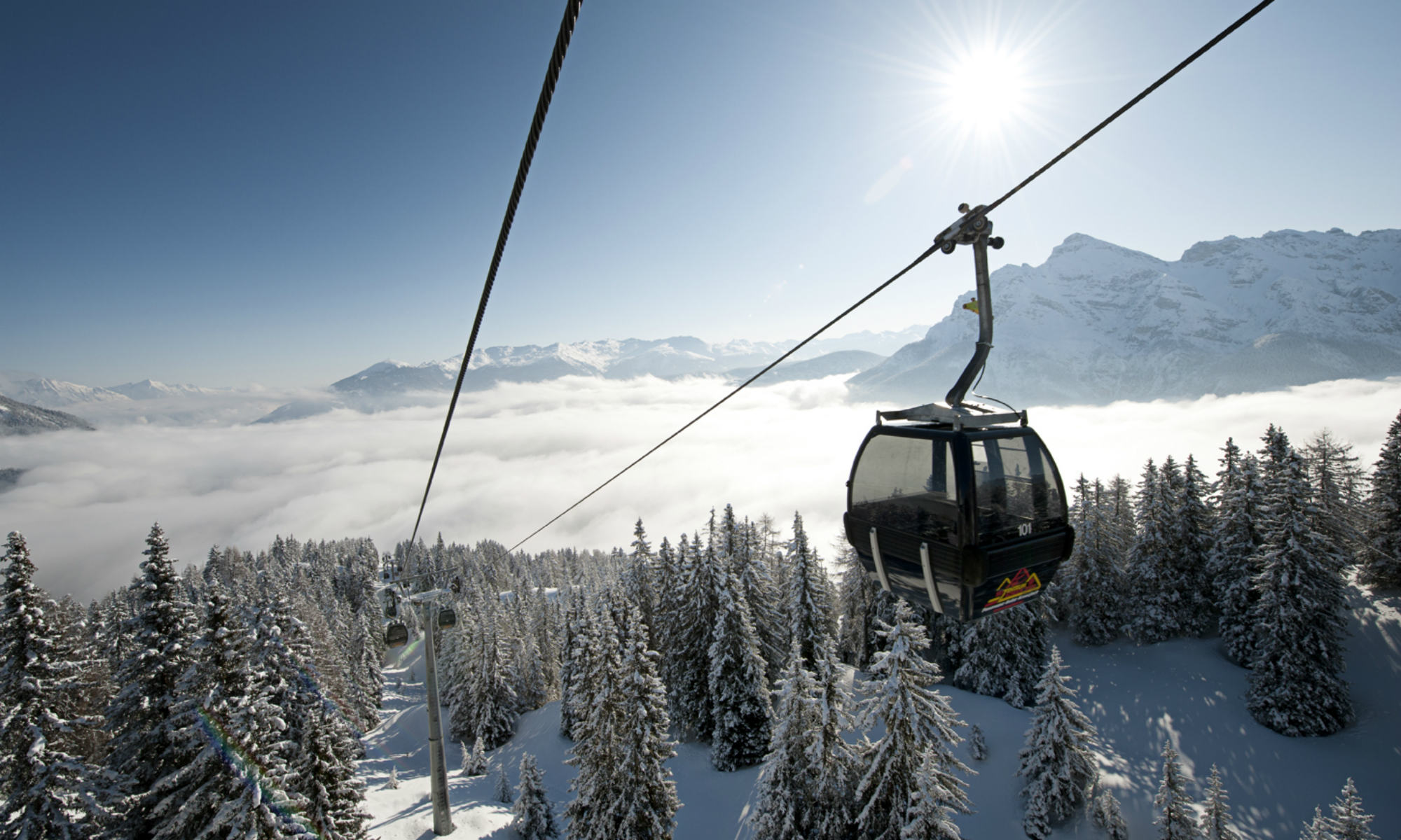 Die Gondelbahn aufs Kreuzjoch mit Bergpanorama im Hintergrund.