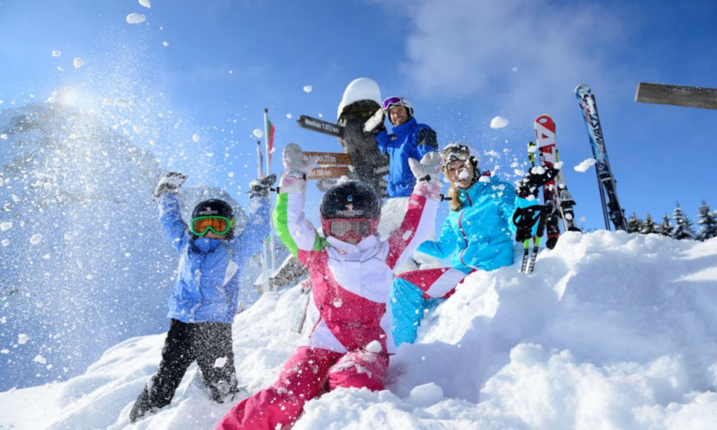 A group of kids having fun in deep powder snow in the Kitzbühel Alps.