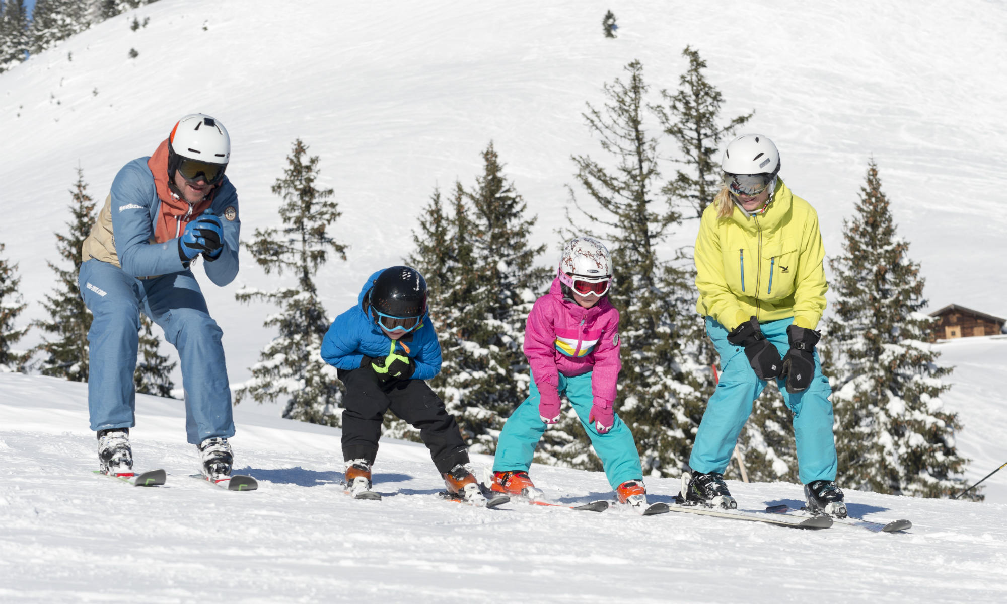 4 Skifahrer fahren gemeinsam auf einer sonnigen Piste in Flachau Ski.