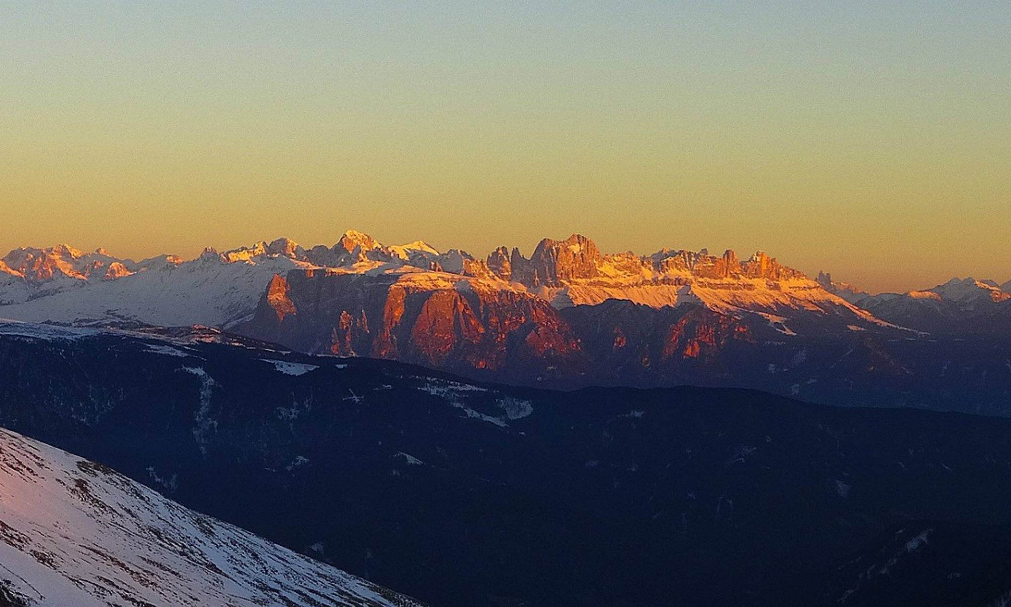 Ausblick auf die rosa verfärbte Rosengartengruppe während der Dämmerung in Südtirol.