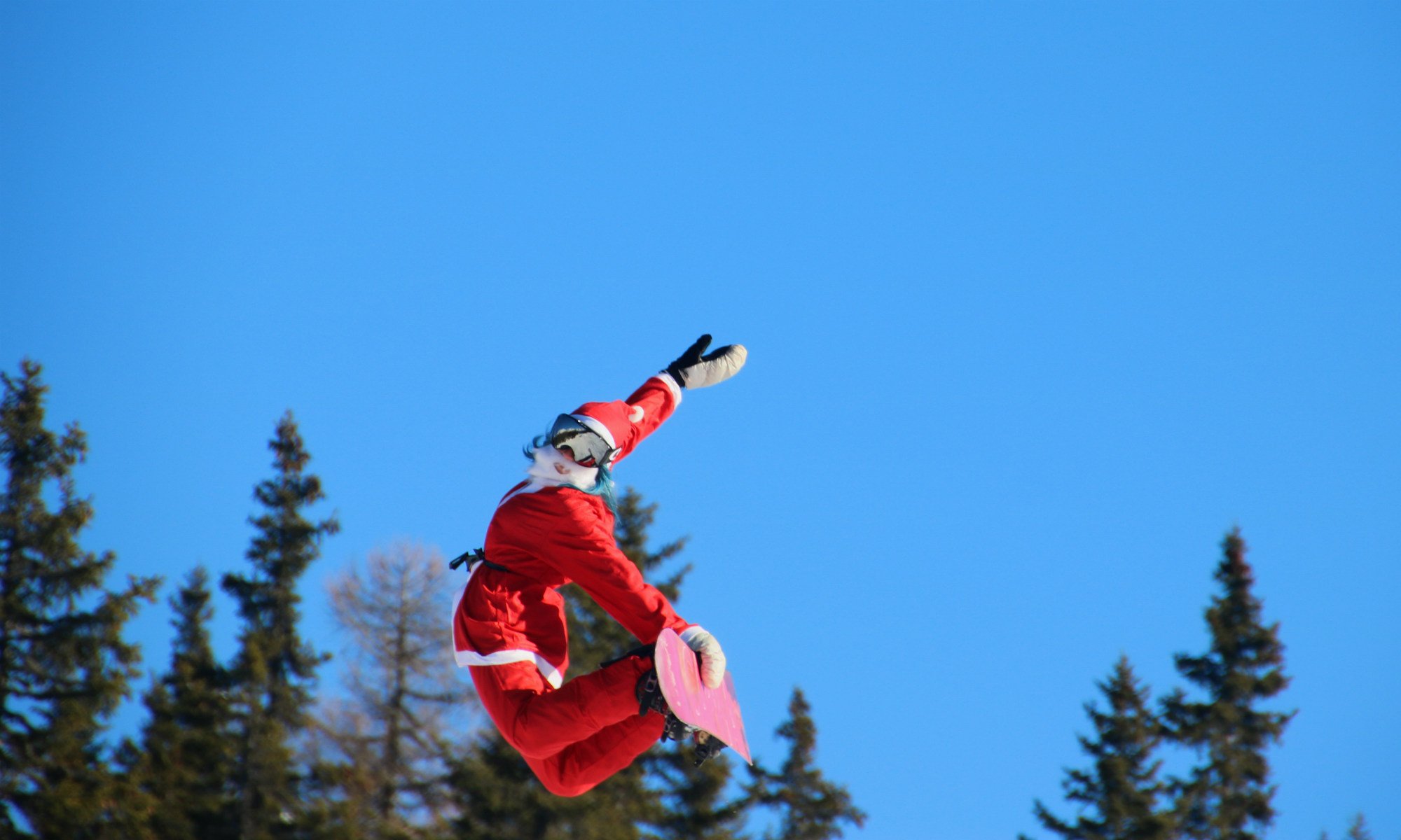 Un maestro di snowboard in Val Malenco vestito da Babbo Natale. 