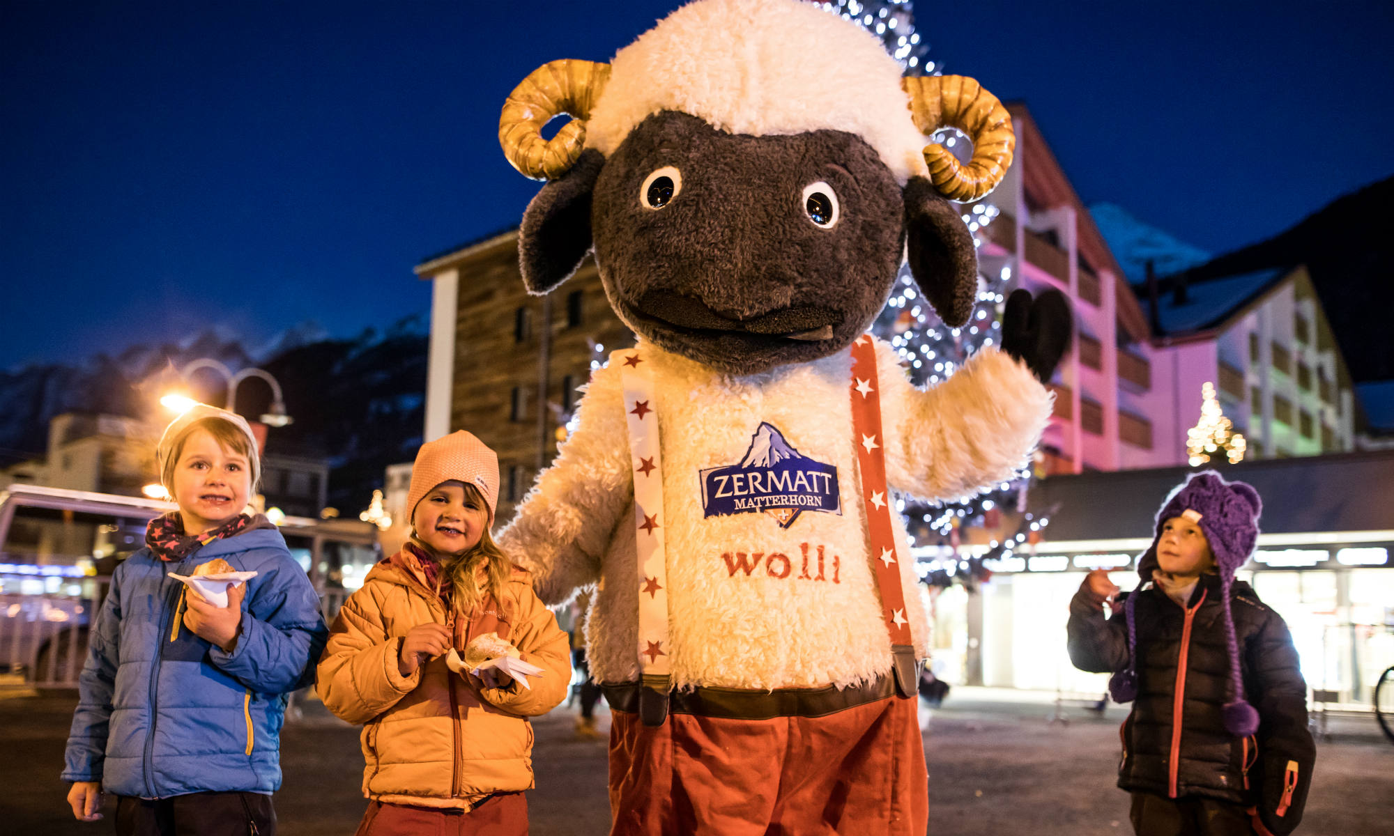 Zermatt’s mascot, Wolli, is joined by three kids at the local Christmas festivities. 