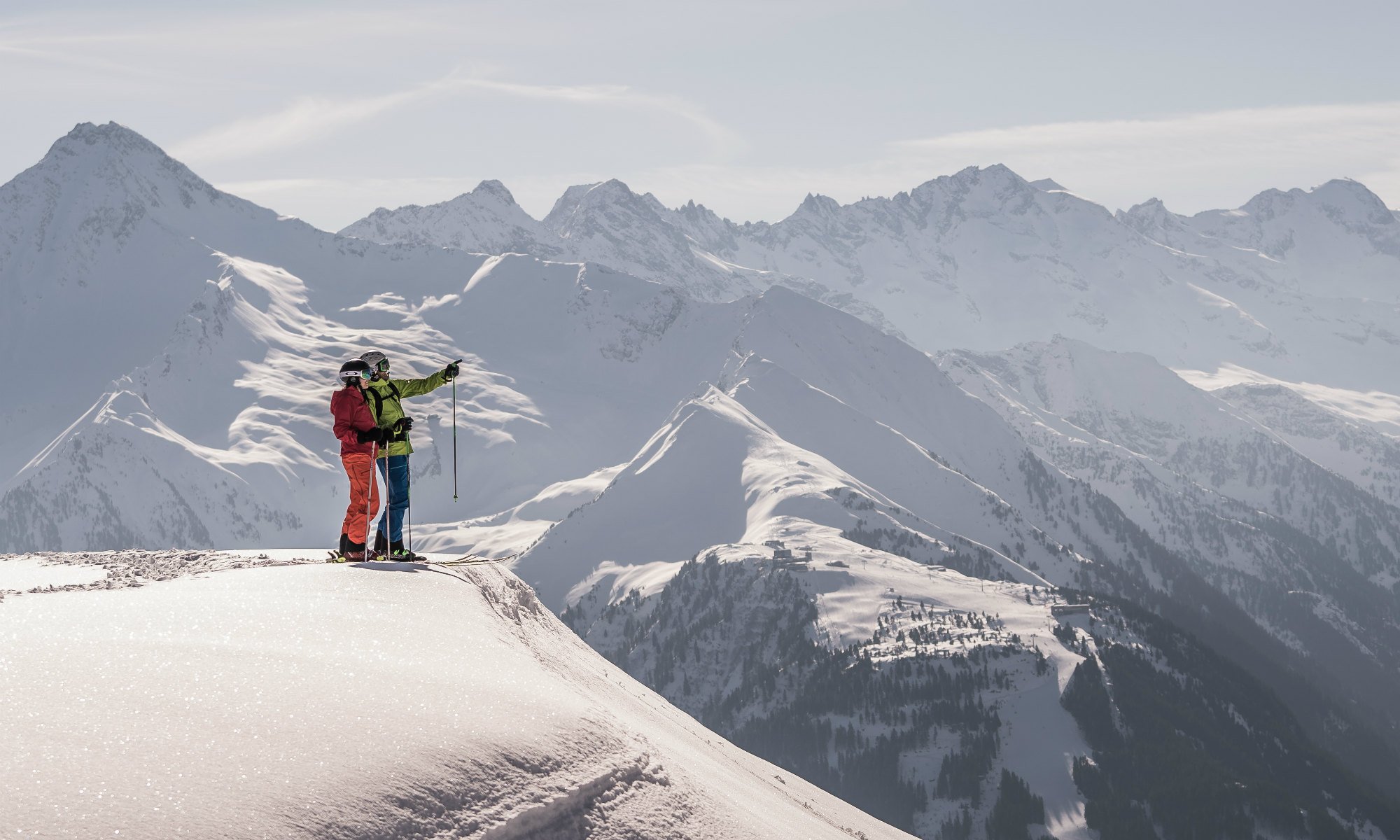 Zwei Skifahrer stehen vor dem Bergpanorama des Zillertals auf einer Piste im Skigebiet Mayrhofen.