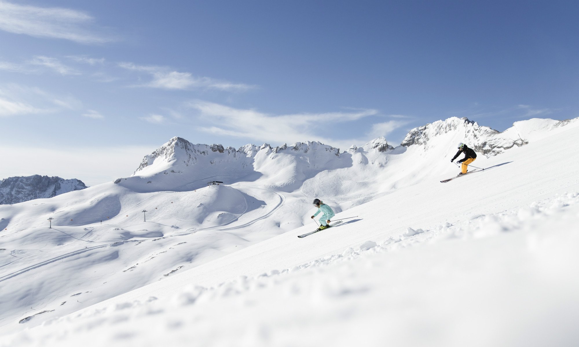 Skifahrer auf einer sonnigen Skipiste im Skigebiet Zugspitze.