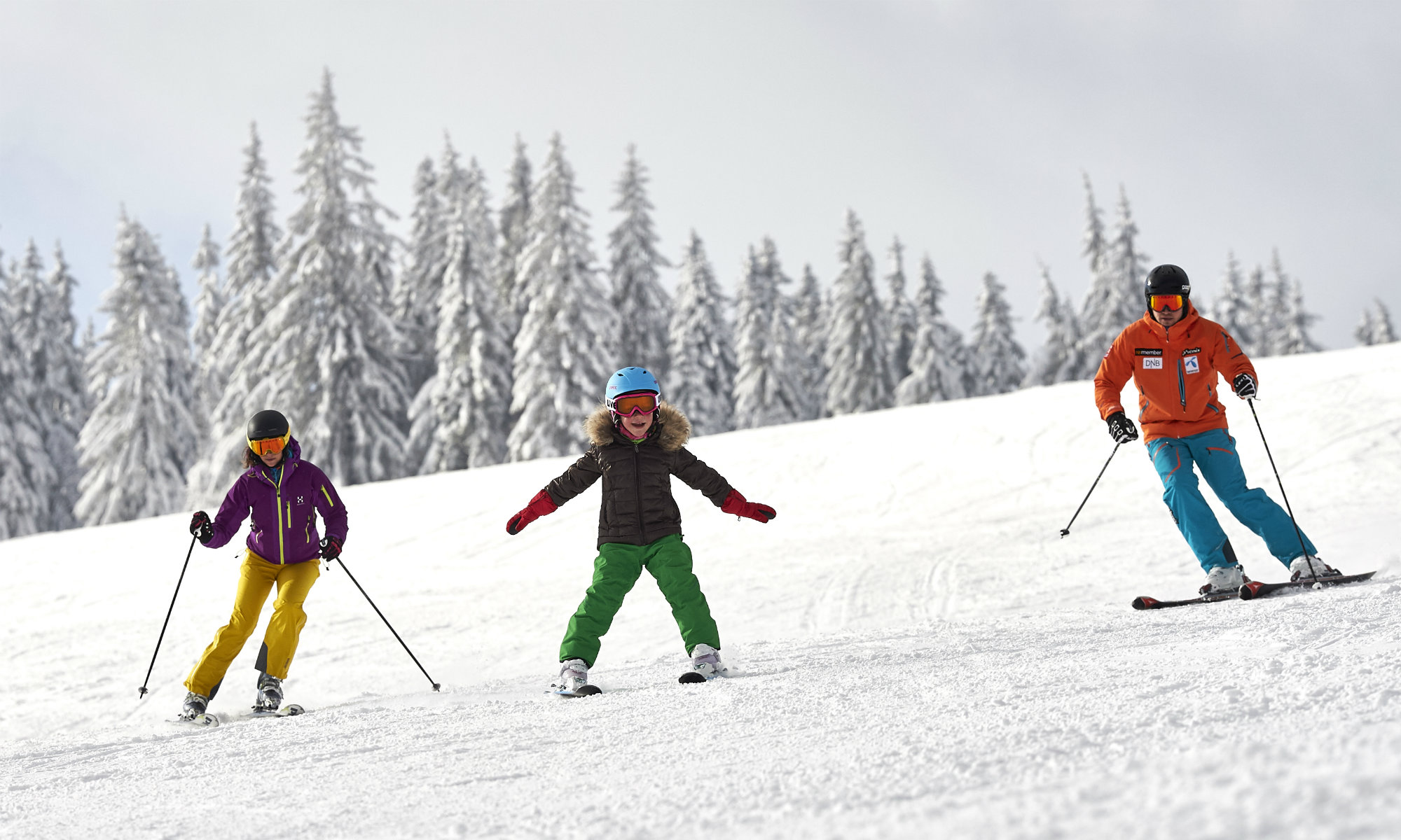 Eine Familie übt das Skifahren auf einer blau markierten Piste am Großen Arber.