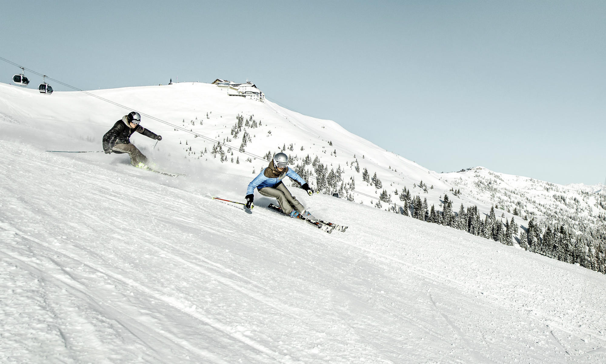 2 skiers on a slope on the mountain Schmittenhöhe in Zell am See.