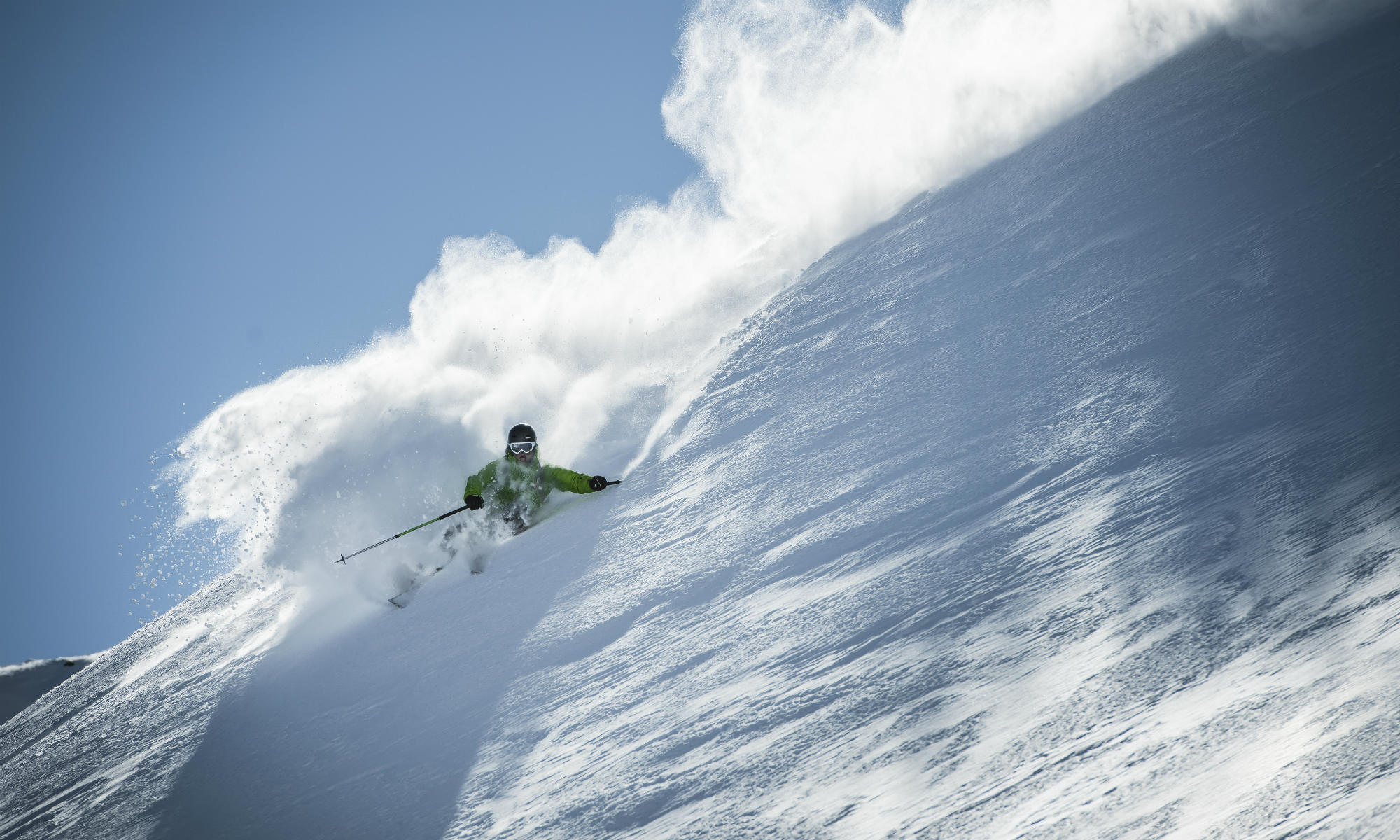 A freeride skier is skiing in deep powder snow.