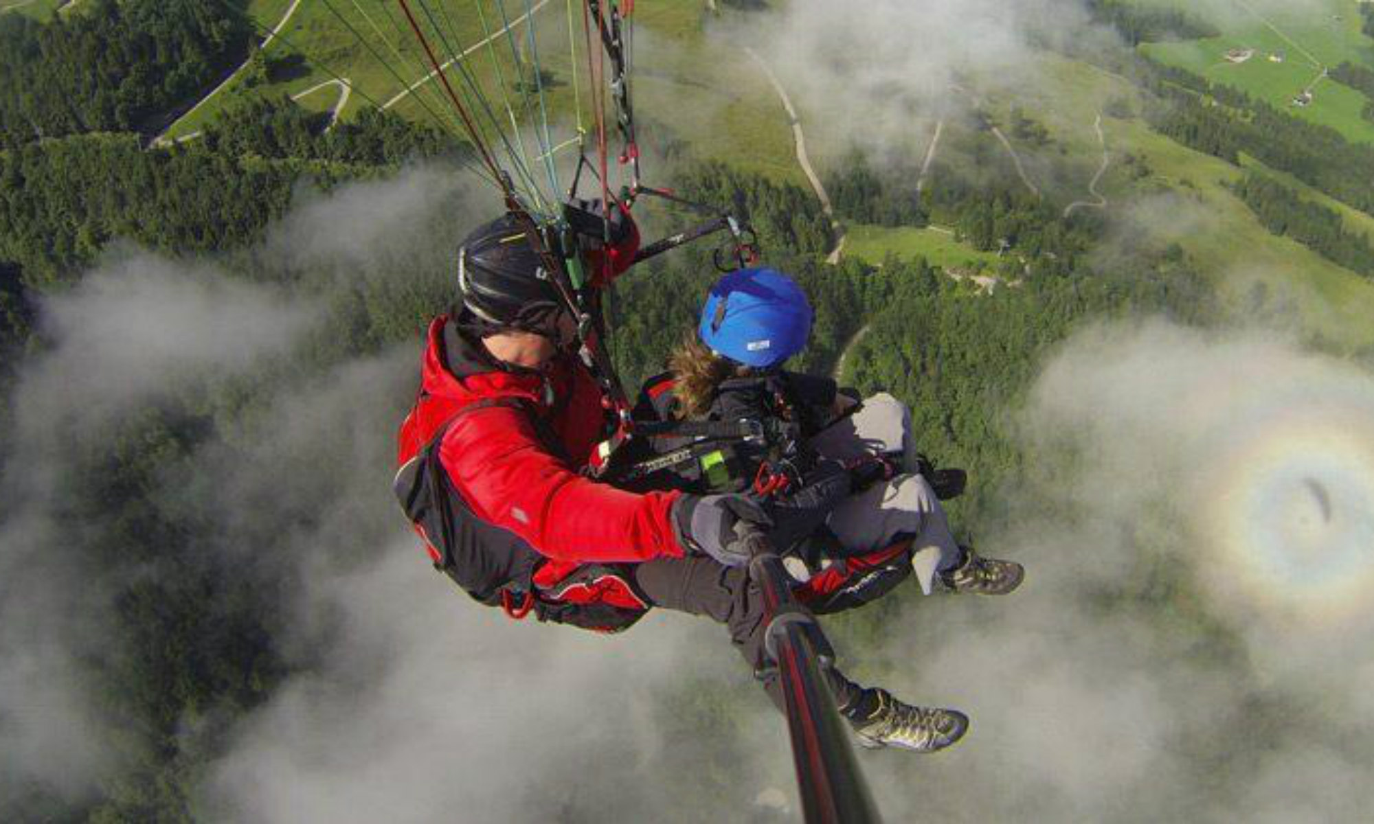 Ein Paragliding Pilot und sein Passagier während eines Fluges über den Chiemgau.