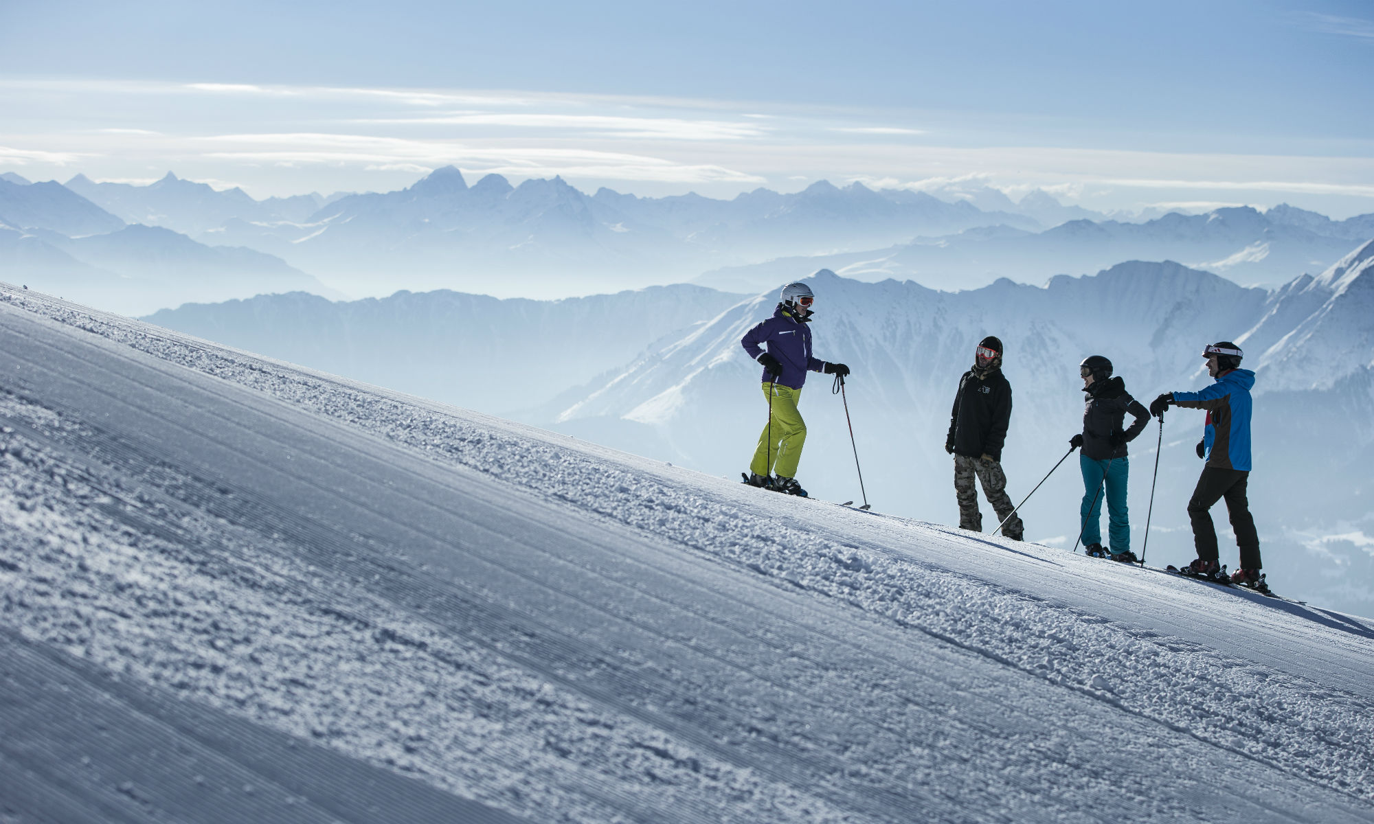 Skifahrer und ein Snowboarder beim Skikurs auf einer Piste im Skigebiet Laax-Flims-Falera.