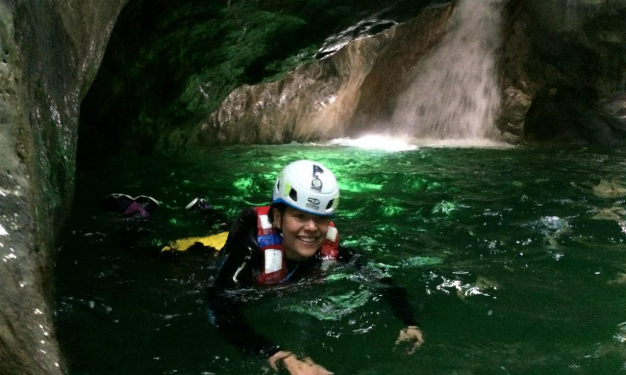 Una ragazza nuota nelle acque del Palvico durante un’escursione di canyoning al Lago di Garda.