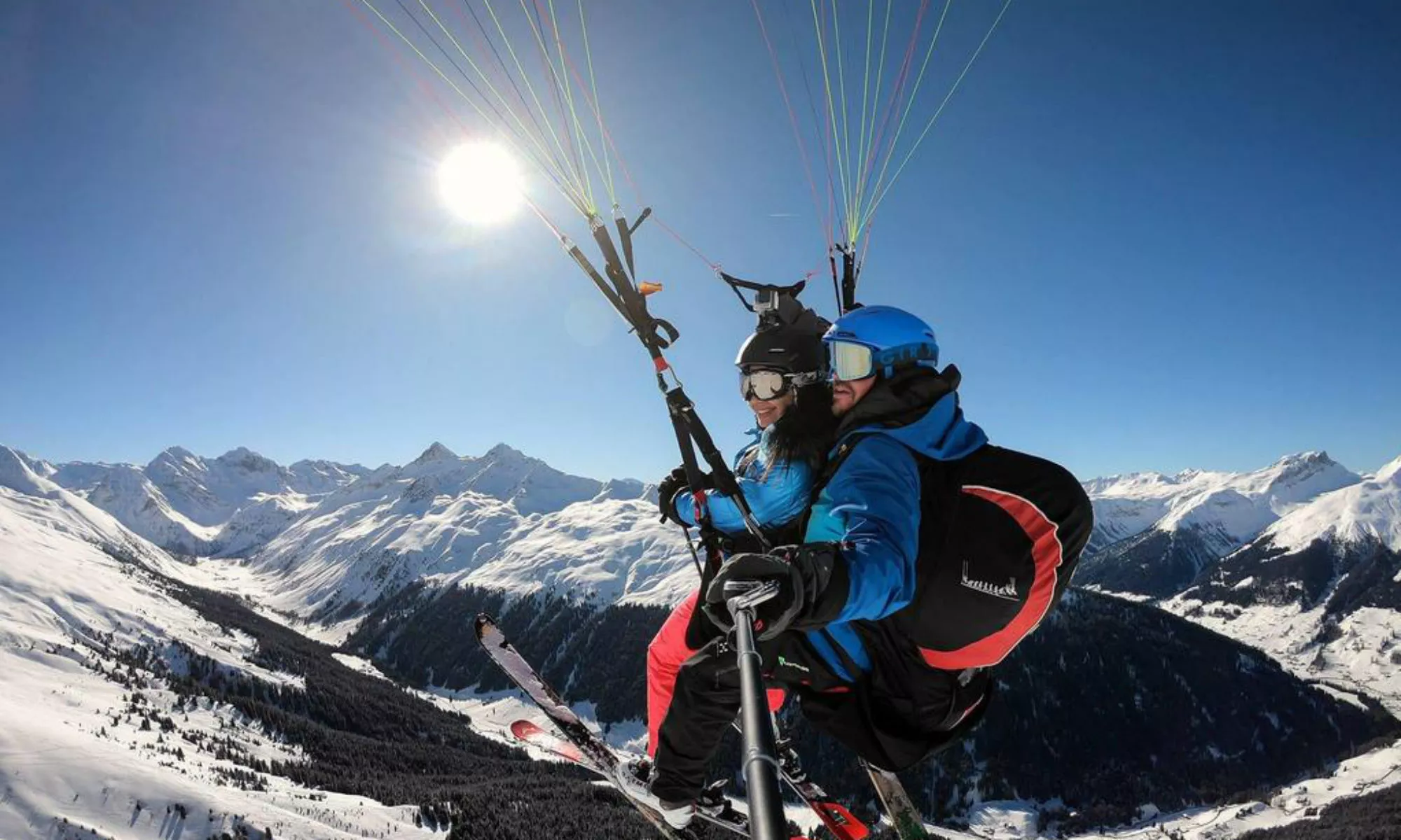 Un pilote de parapente avec un passager au-dessus des montagnes de la région de Davos-Klosters.