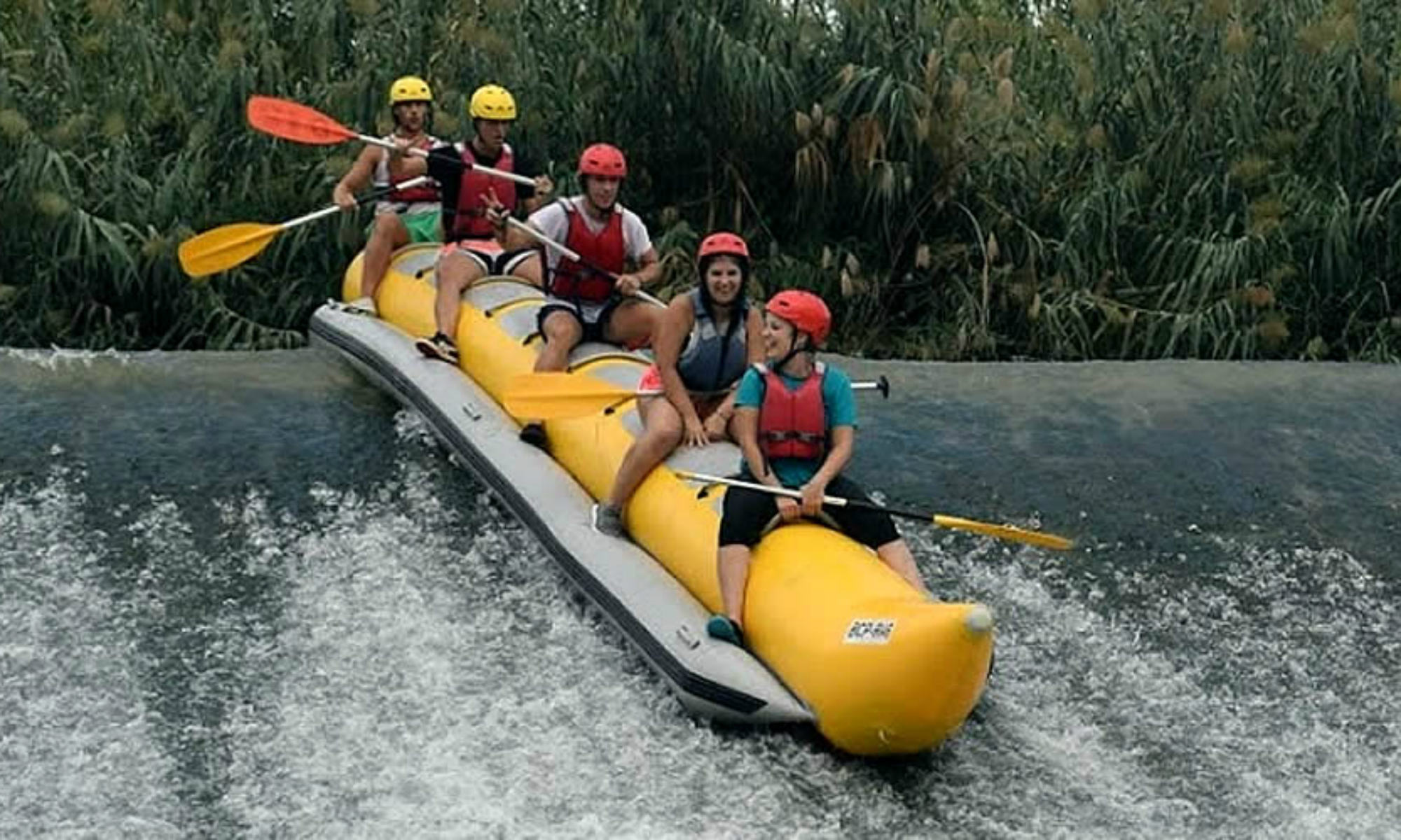 Un gruppo di ragazzi fanno rafting su una banana boat.