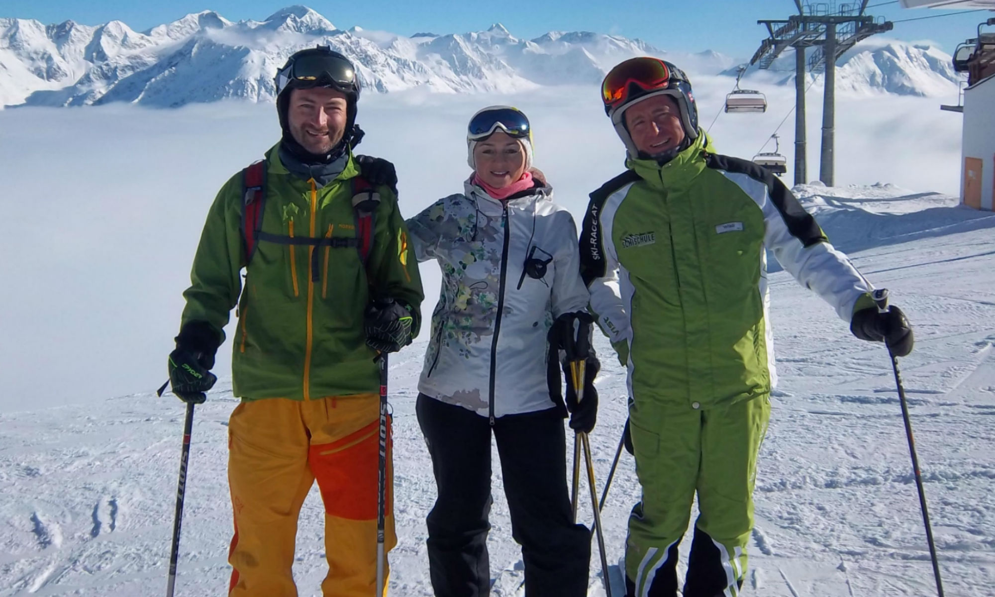 2 Skikurs Teilnehmer zusammen mit einem Skilehrer auf einer sonnigen Piste in Sölden.