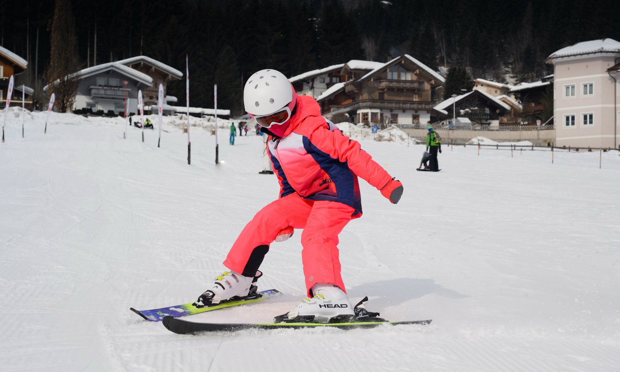 Child skiing down the slope in a snow plough turn.