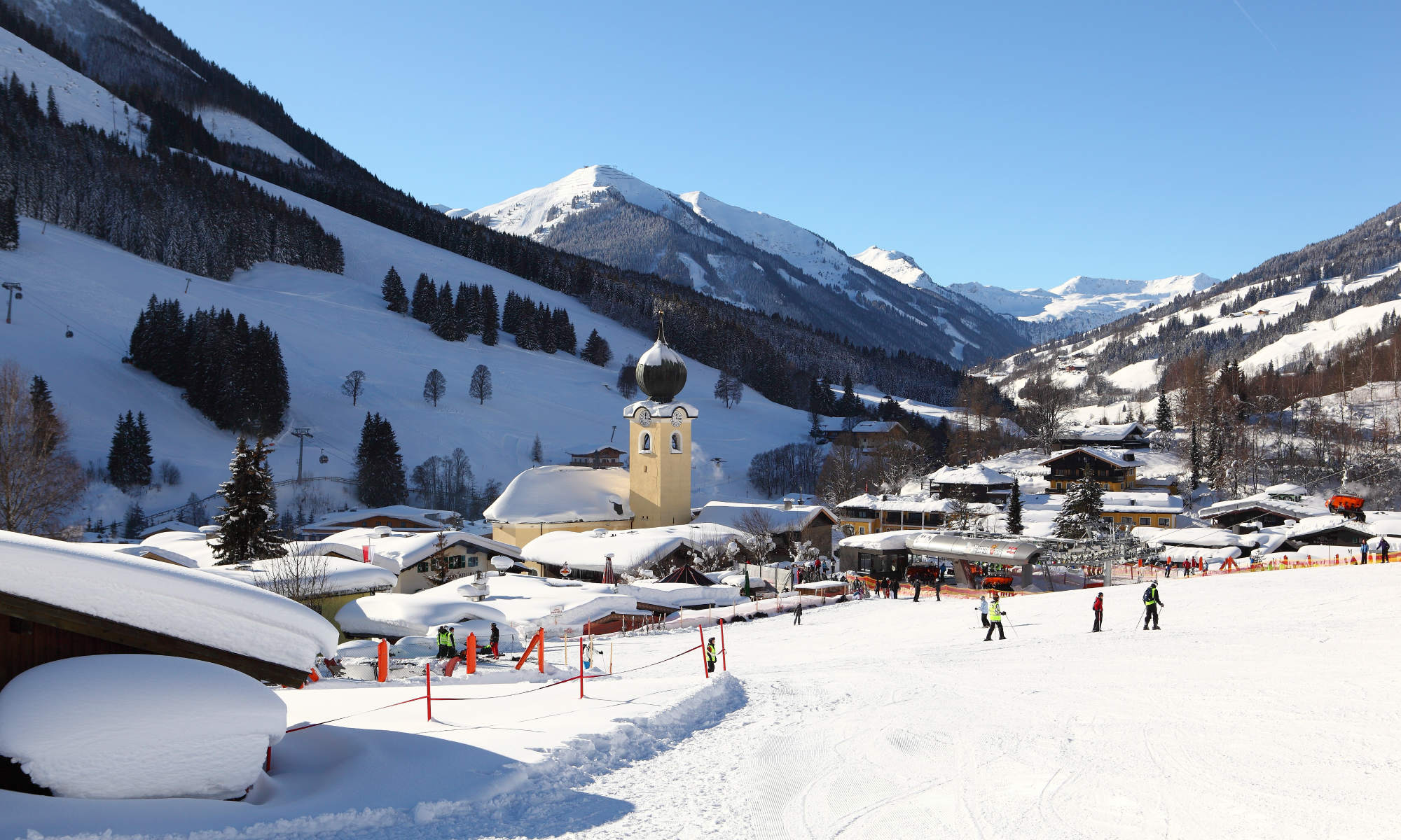 Blik op het pittoreske Saalbach met het herkenbare gele kerkje in het midden. 