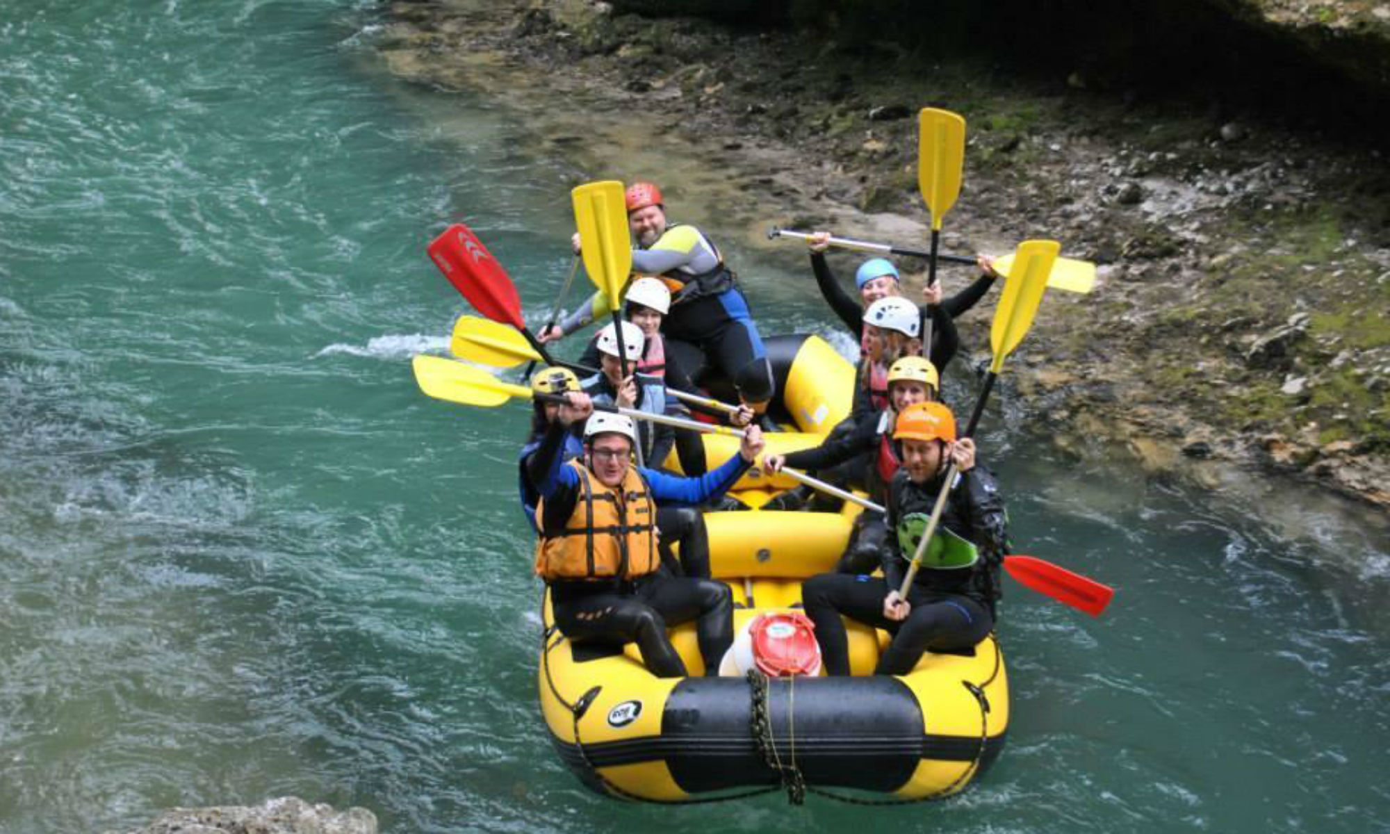 A group of people in a rubber dinghy on the Salza River while out white water rafting in Austria.