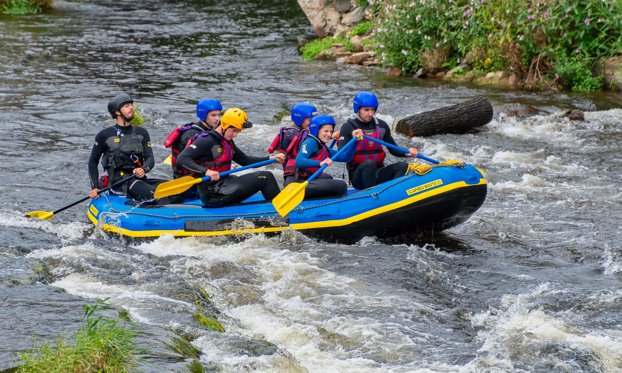 A group of people rafting along the River Dee in Wales.
