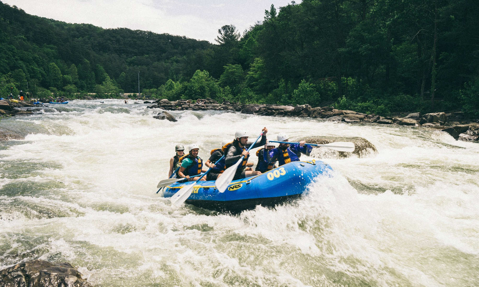 A group of people rafting on a turbulent river.