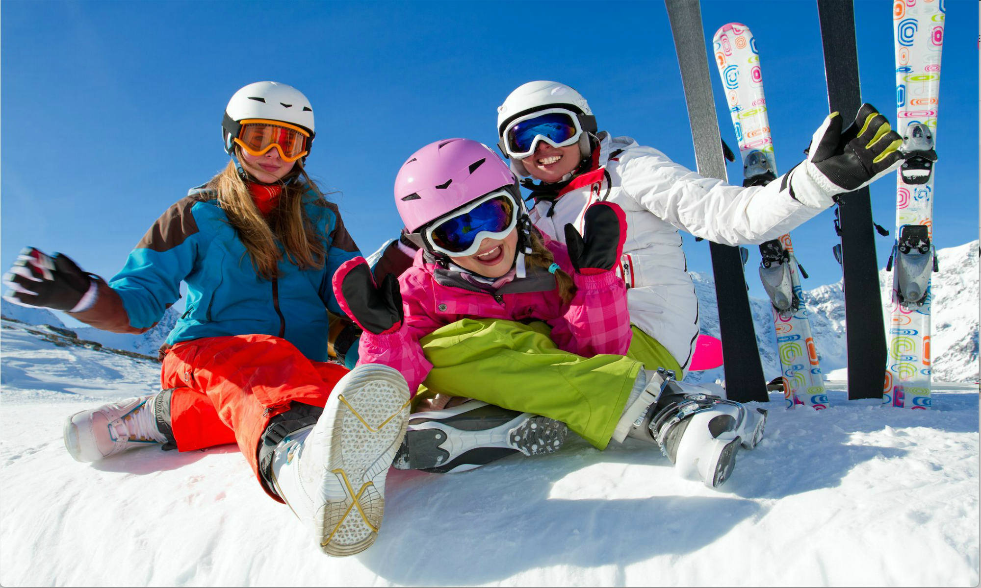 Family of happy skiers sitting on a snowy slope in Méribel.