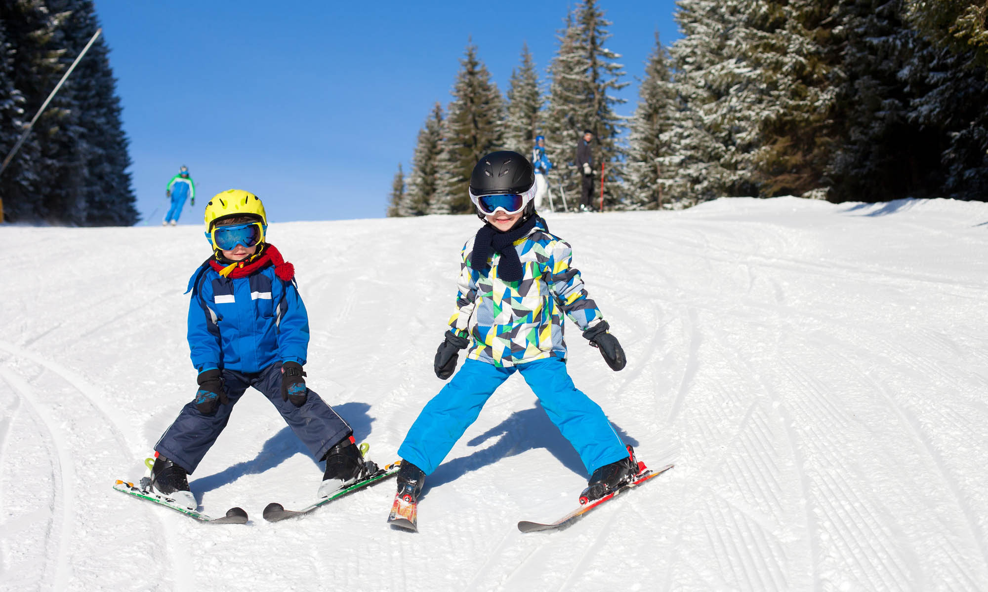 Twee jonge kinderen op ski’s laten zien dat ze de sneeuwploeg beheersen.