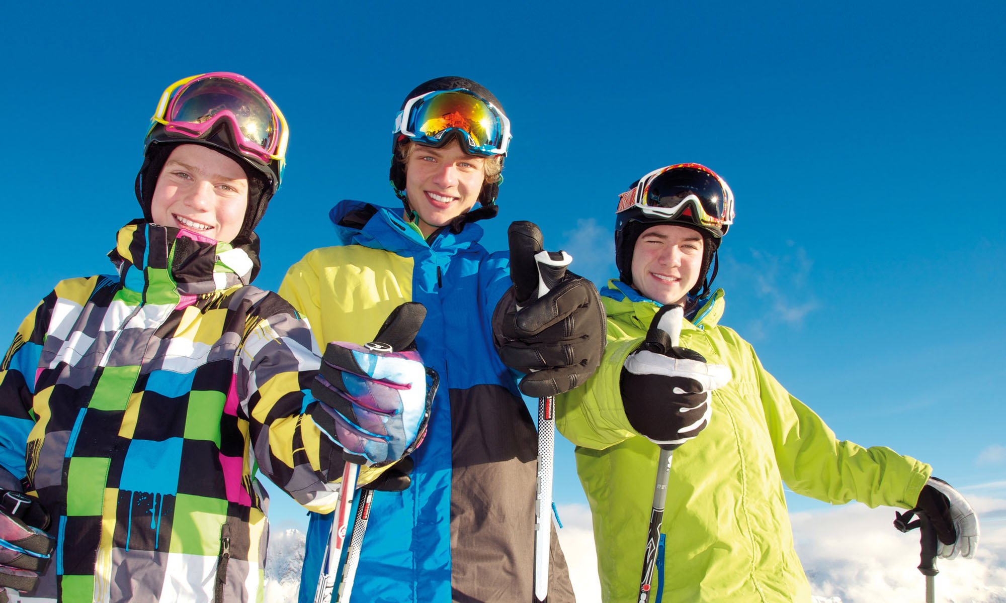 A group of teenage skiers giving a thumbs up.