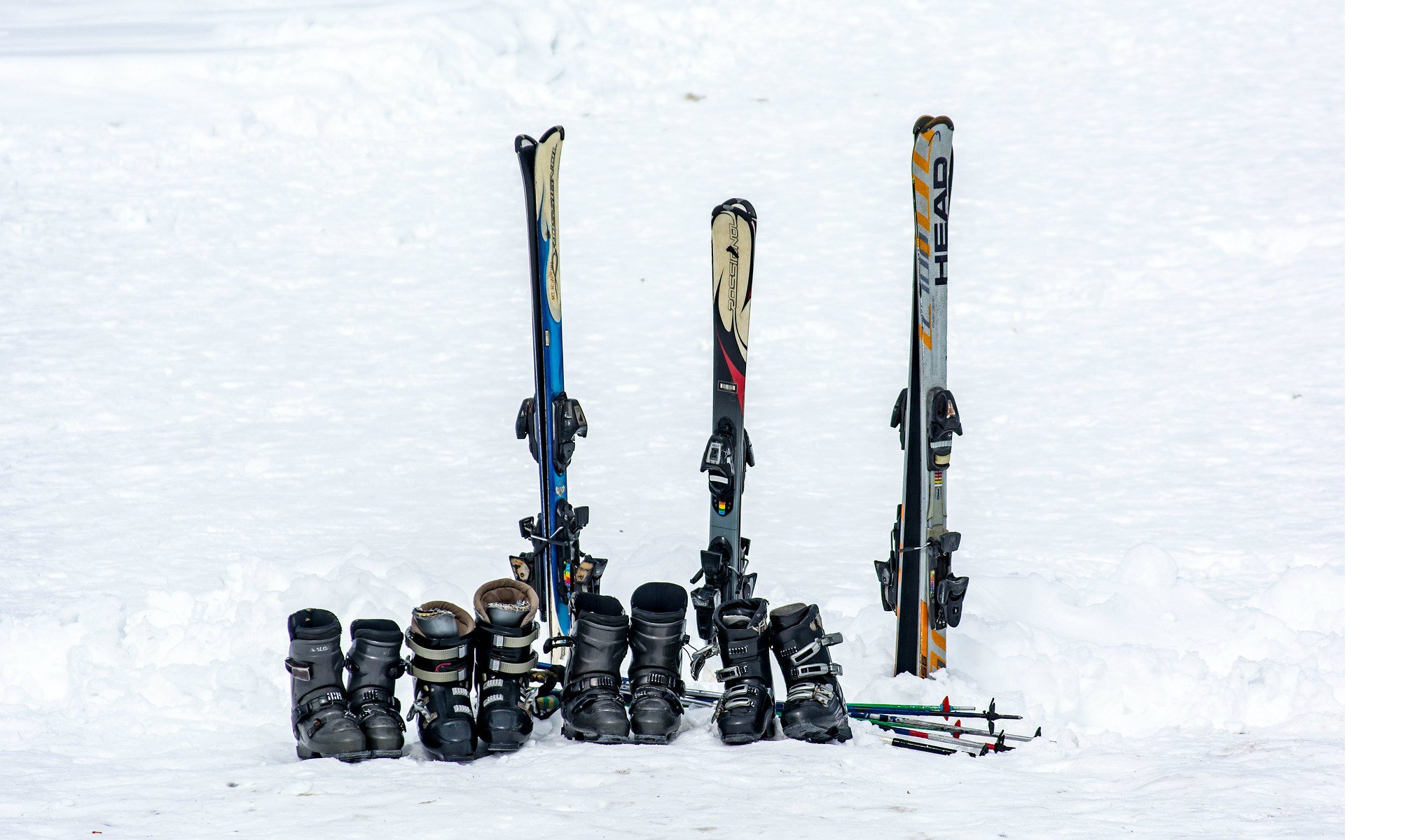 Blik op ski’s, skischoenen en skistokken in de sneeuw.