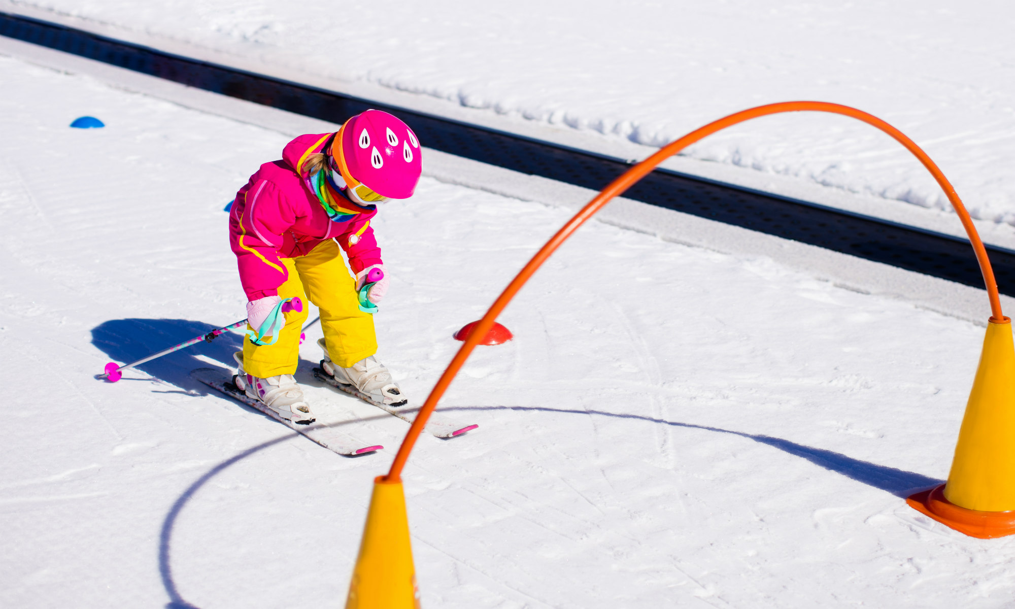 Una piccola sciatrice si appresta a sciare attraverso un ostacolo sulla neve a Bormio.