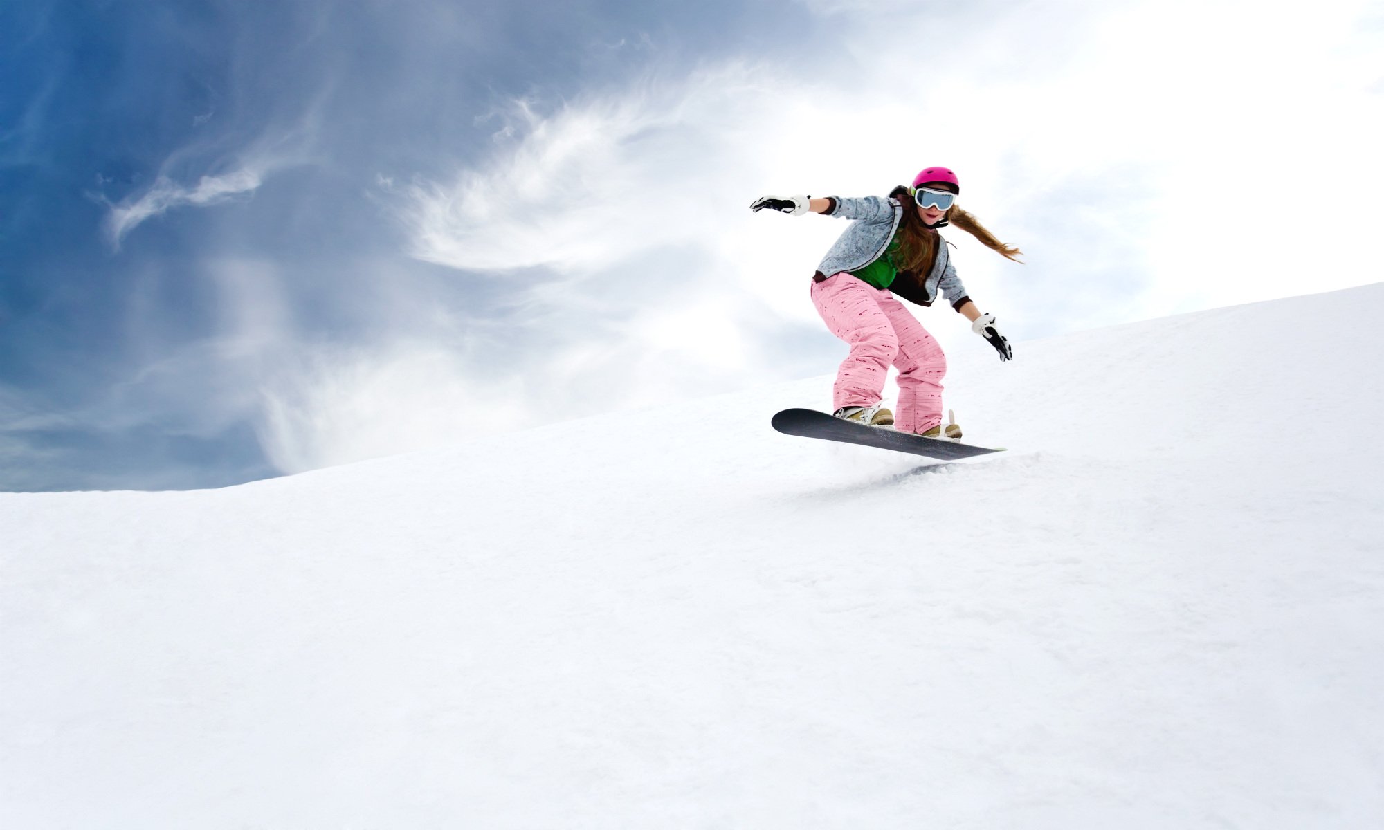 Female snowboarder riding on off-piste terrain.