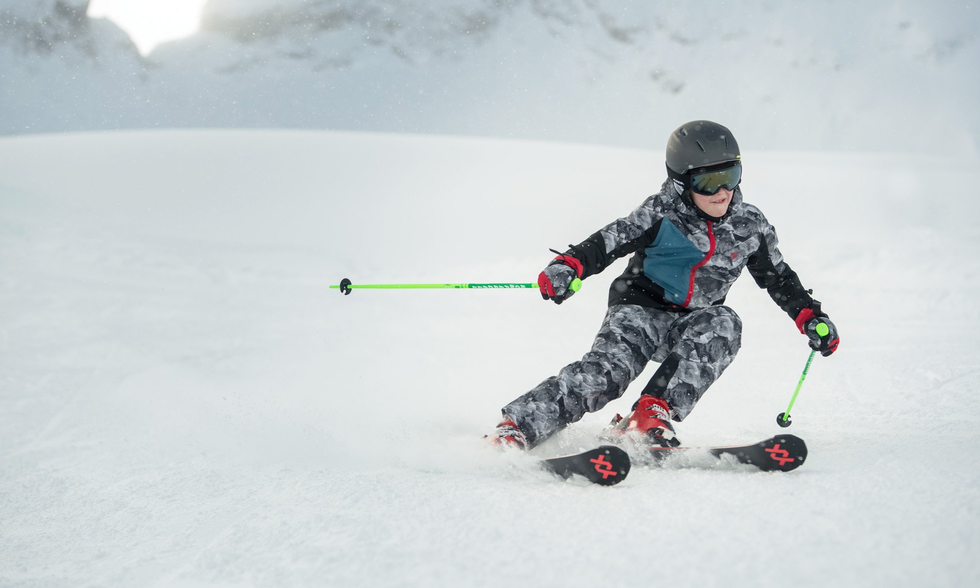 Un garçon en tenue de ski camouflage.