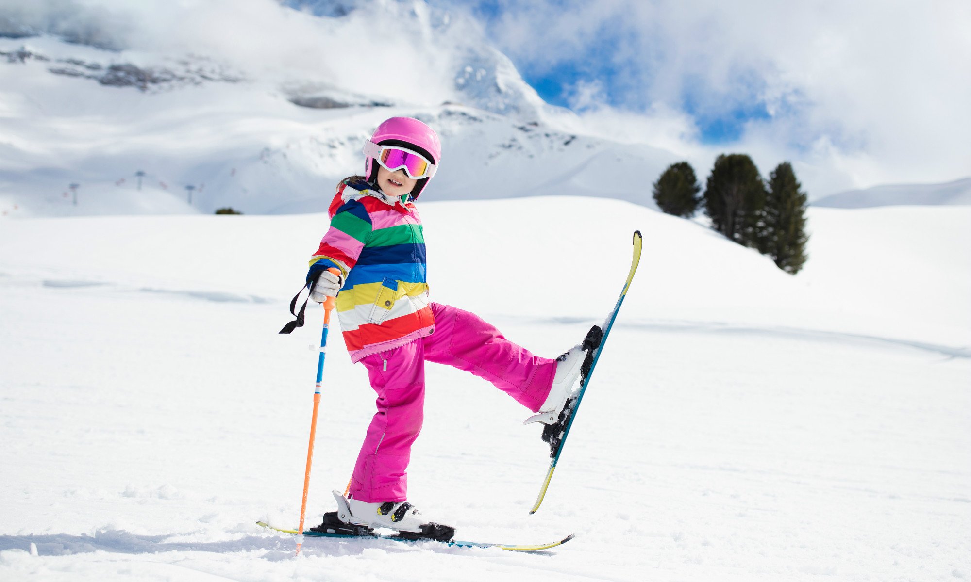 Una piccola sciatrice mostra gli sci ai piedi