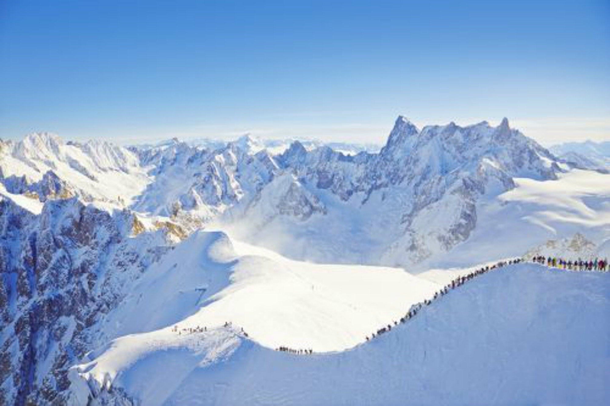 Des skieurs descendent la crête de l’Aiguille du Midi avant de se lancer dans la descente de la Vallée Blanche.
