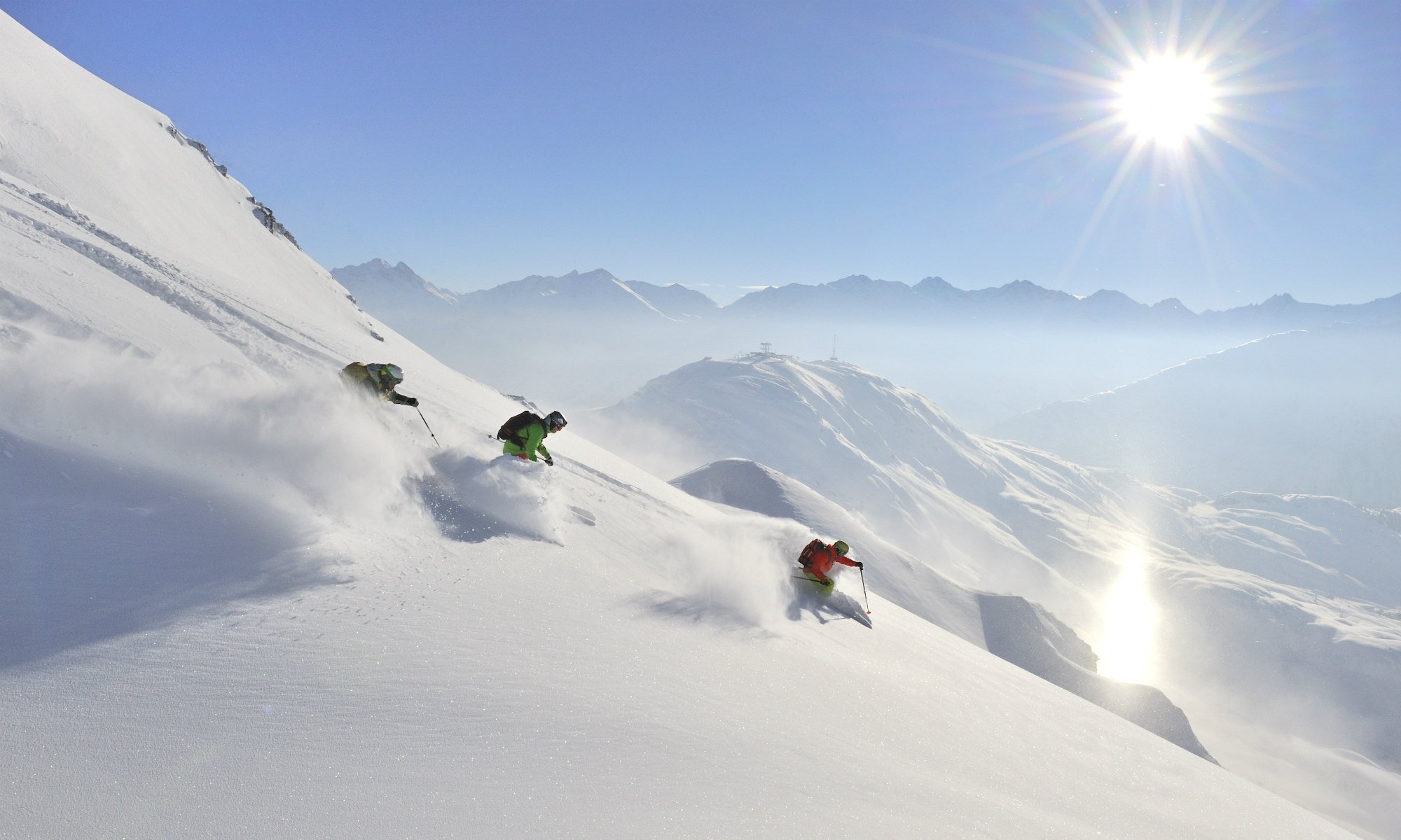 Three freestyle skiers on powder snow in St. Anton.