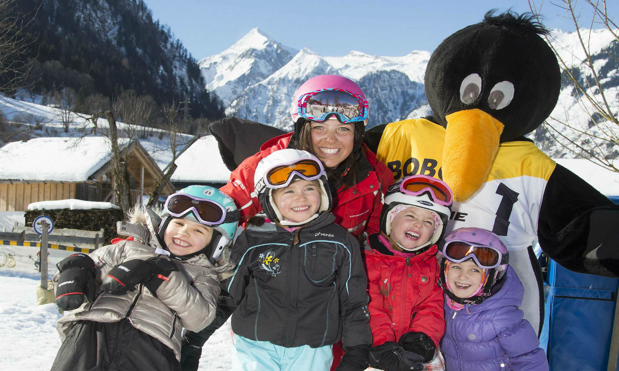 Vier meisjes hebben veel plezier met hun skilerares en Bobo de pinguïn.