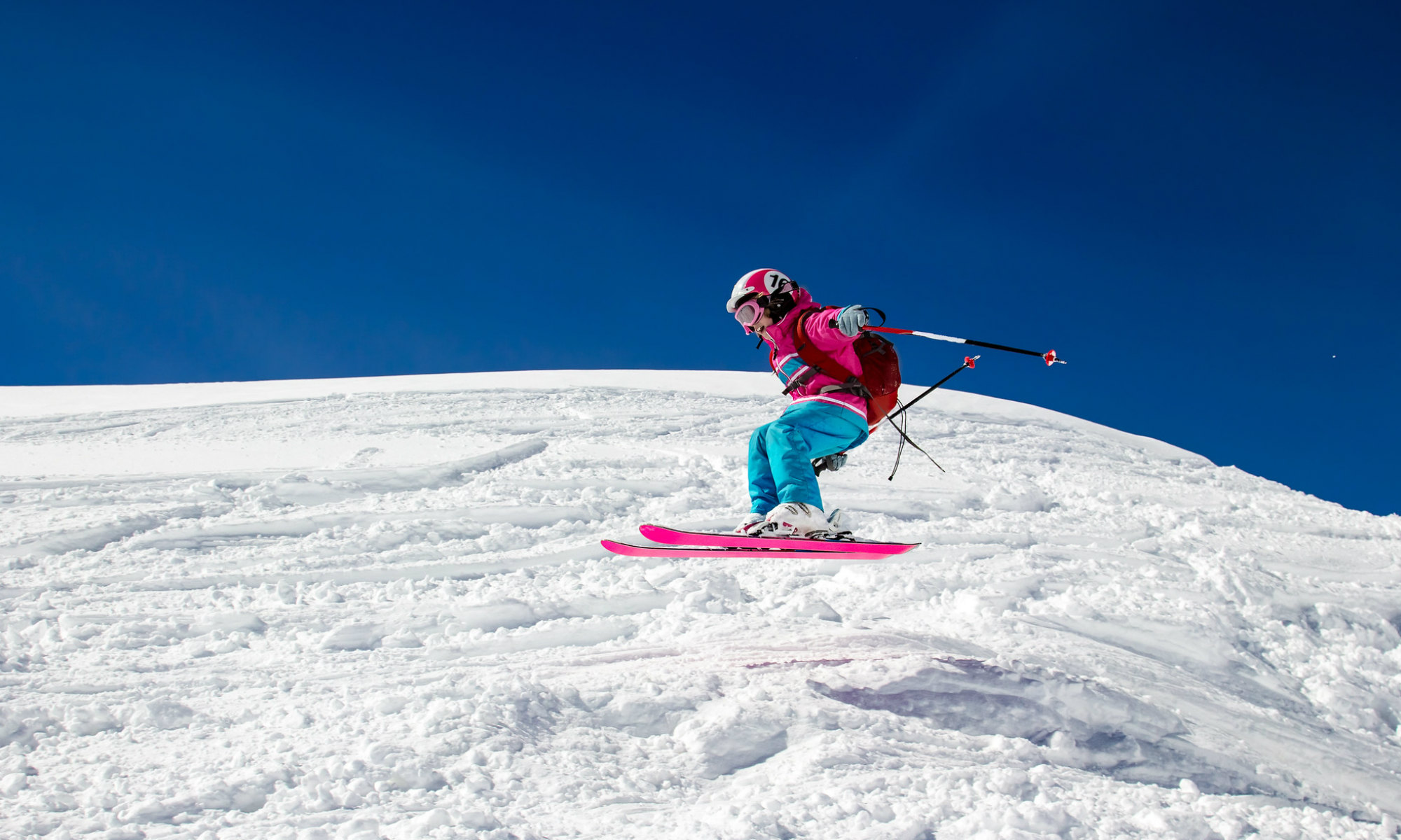 Une jeune ado effectue un saut lors d’un cours de ski hors piste aux Arcs.