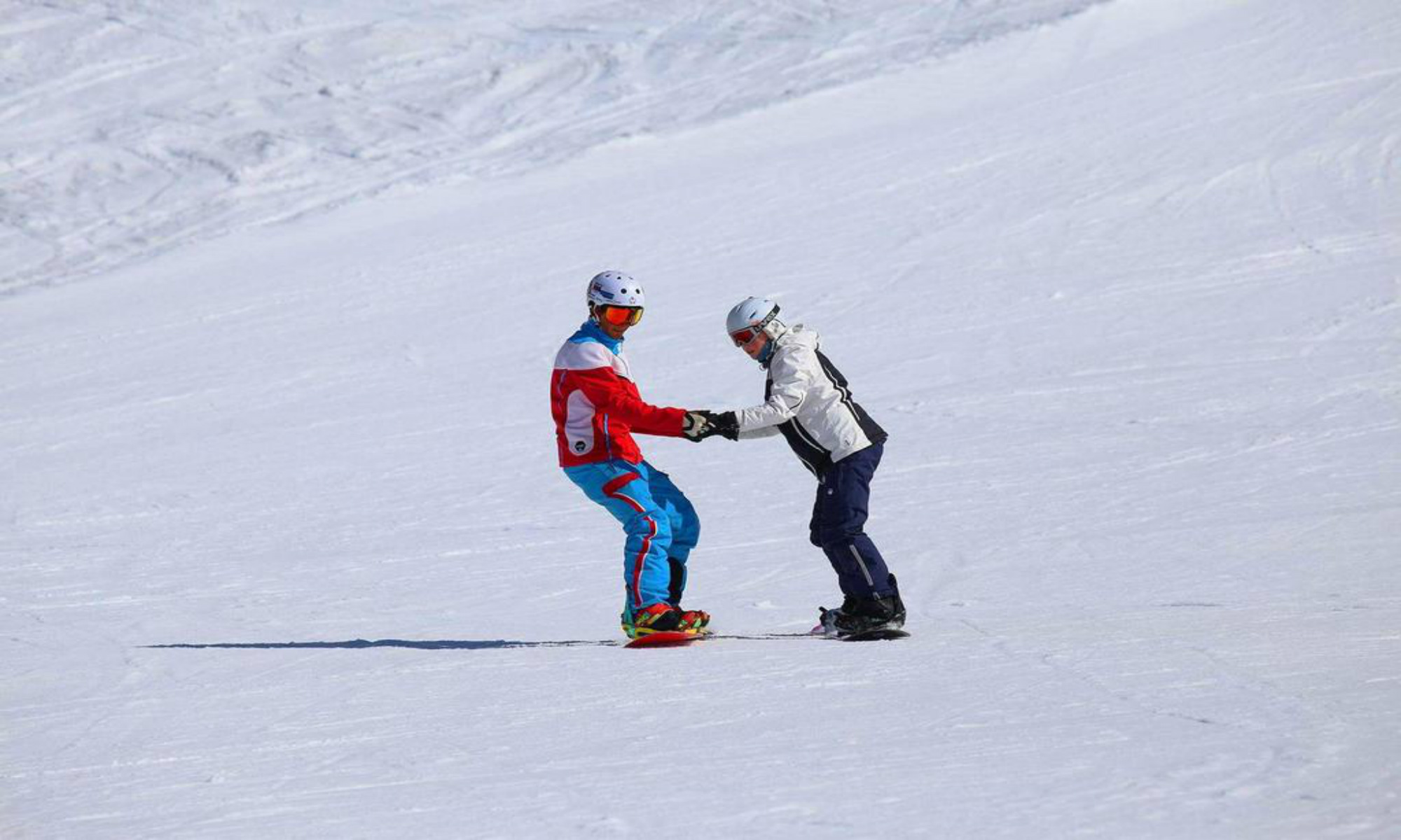 Een privéleraar en zijn leerling tijdens een snowboardles in het skigebied van Ischgl.