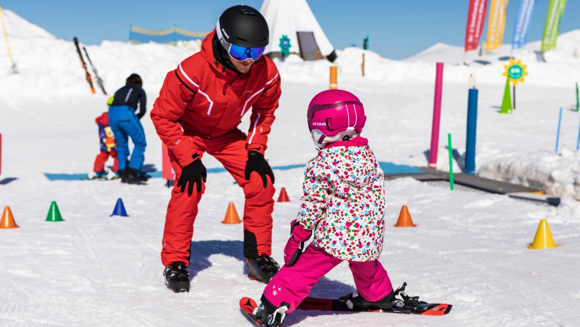 Un maestro di sci insegna a sciare a una bambina.