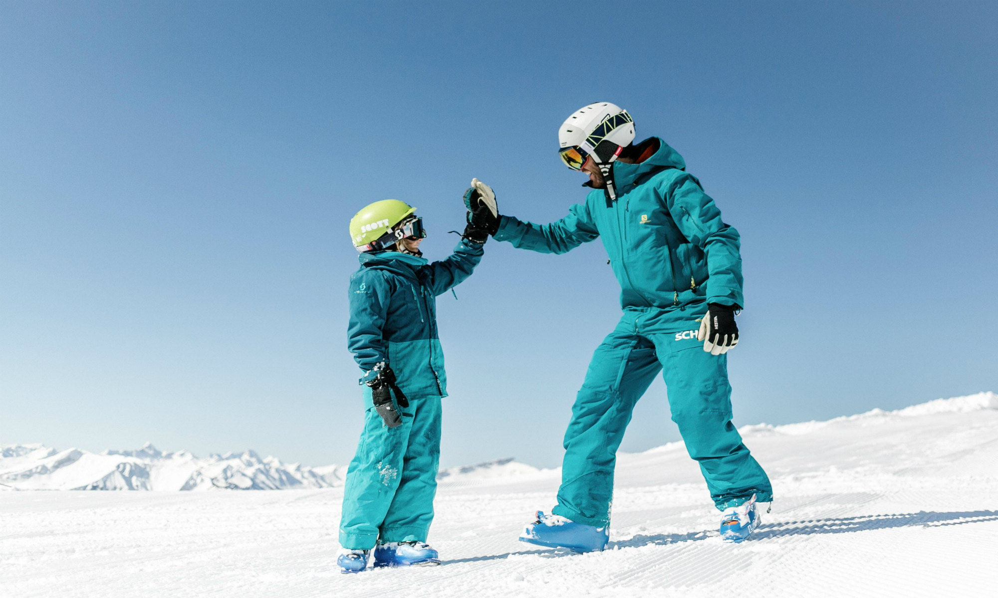 Een skileraar geeft zijn leerling een high five tijdens een skiles in het skigebied van Oberstdorf.
