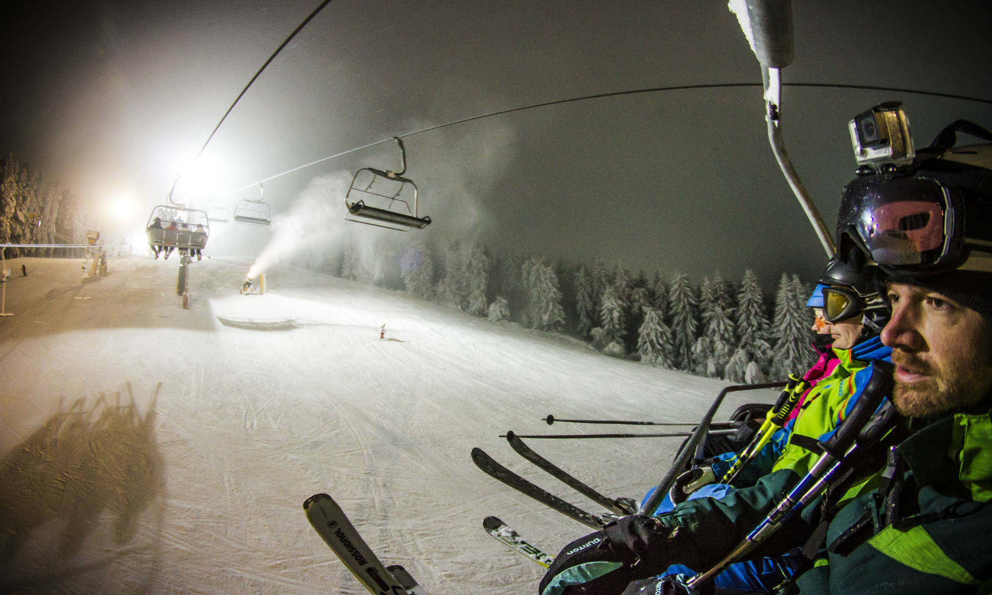Skiërs hebben vanuit een skilift uitzicht op een verlichte piste in Winterberg.