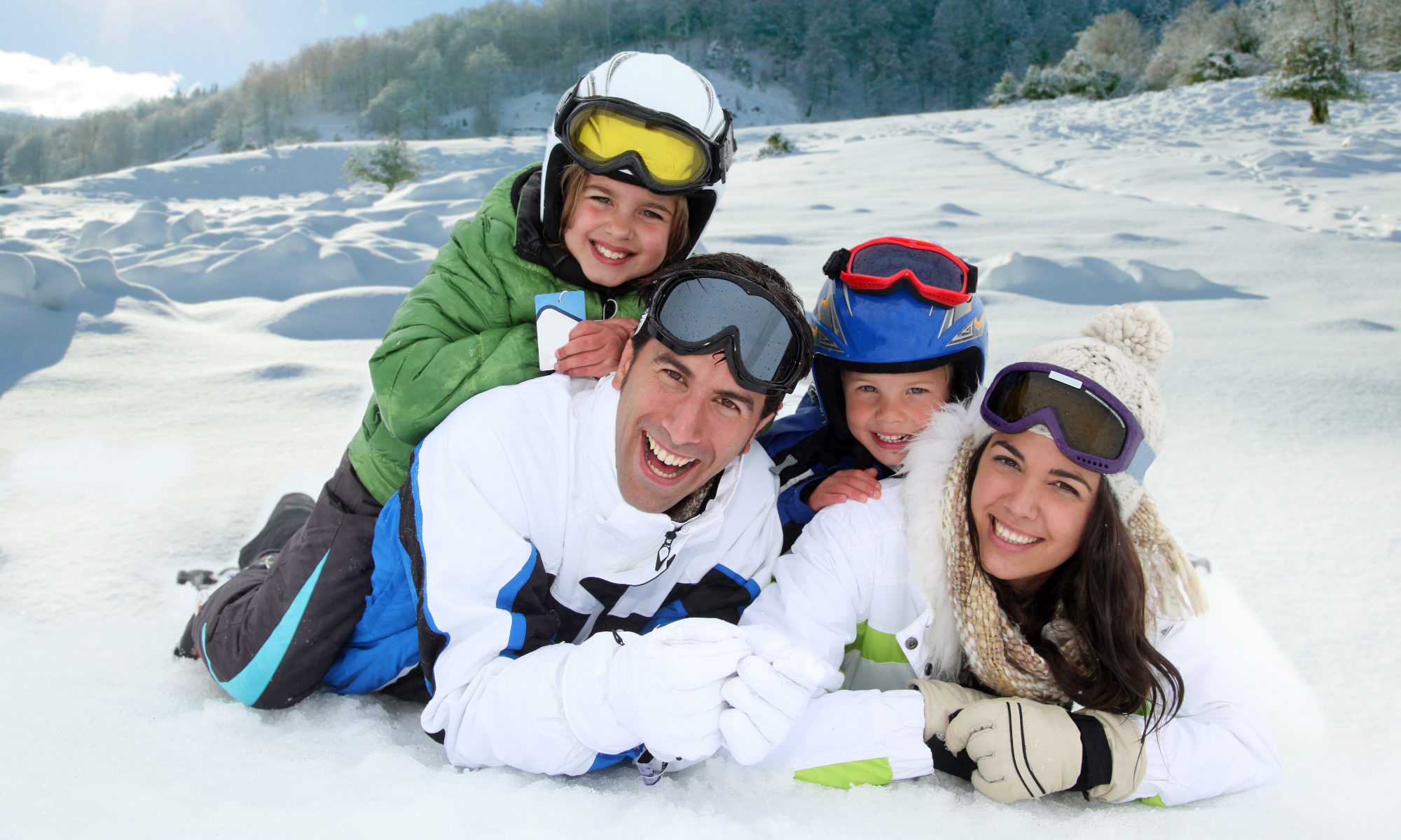 Una famiglia distesa sulla neve verso la macchina fotografica.