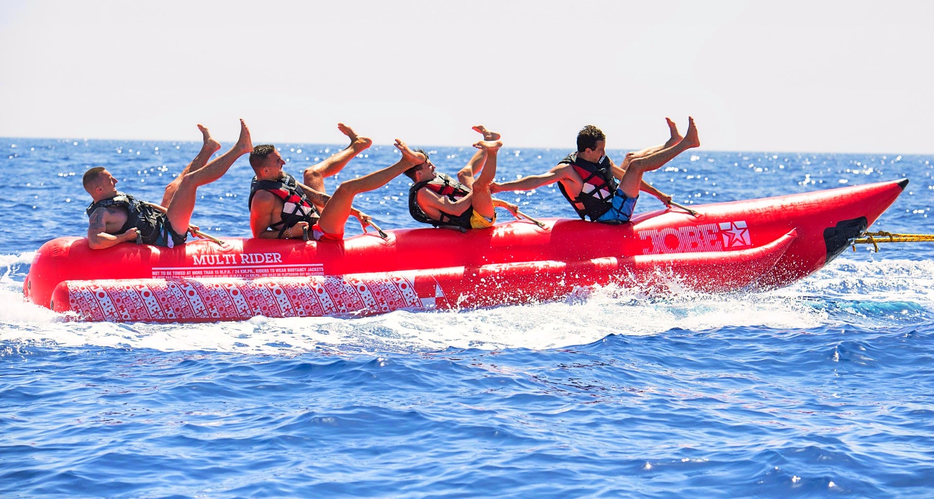 Four guys have fun on a banana boat in Malta.