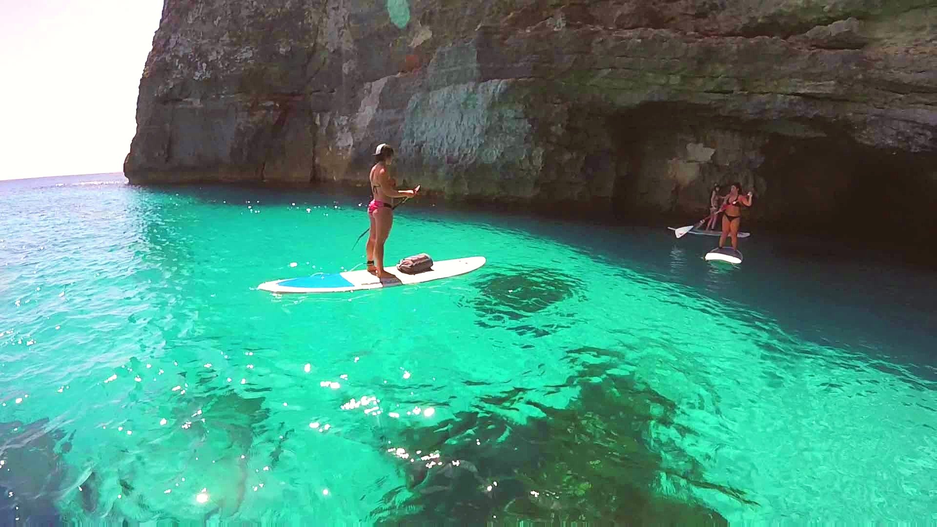 Two girls explore a cave while doing SUP in Malta.